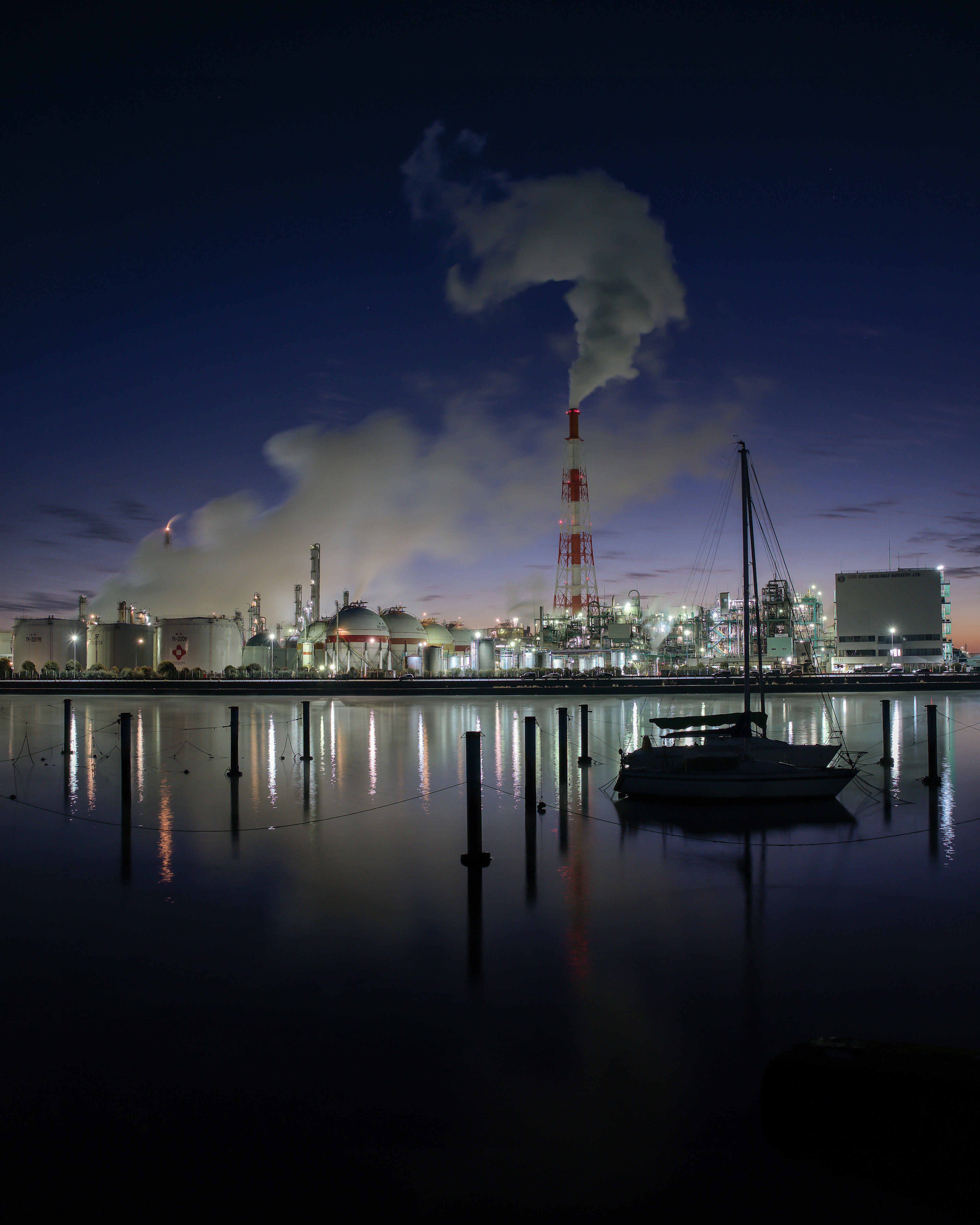 Night view of an industrial area with smoke rising from chimneys