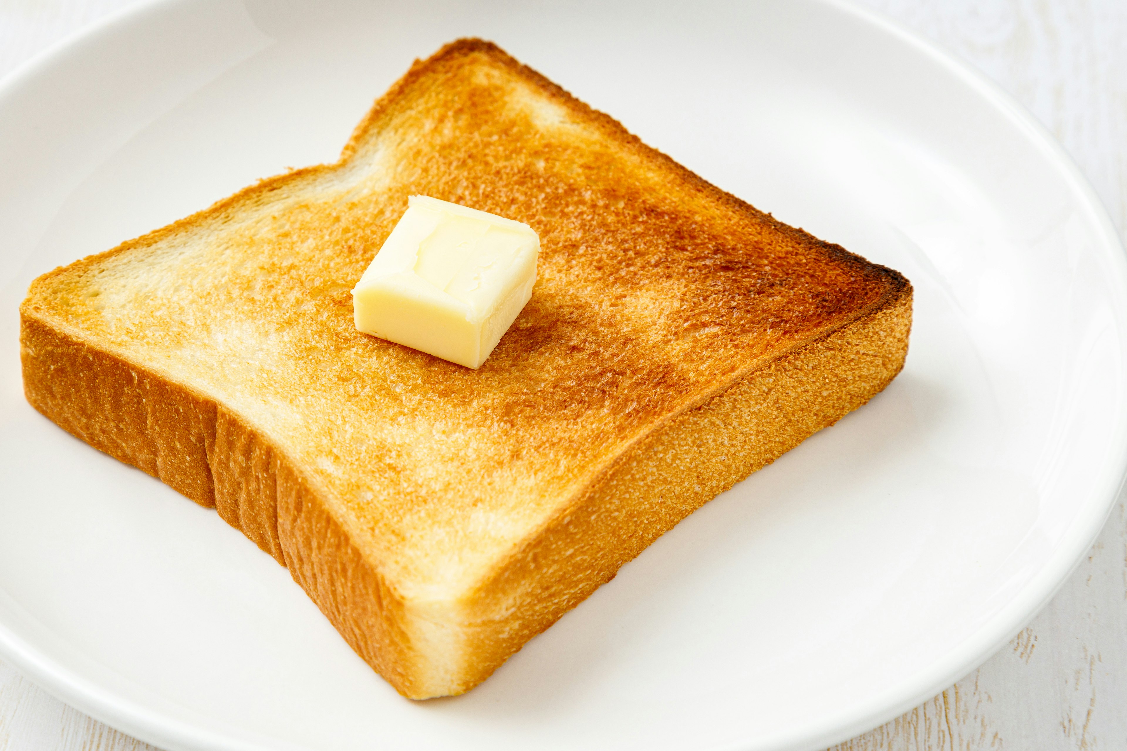 Getoastetes Brot mit Butter auf einem weißen Teller