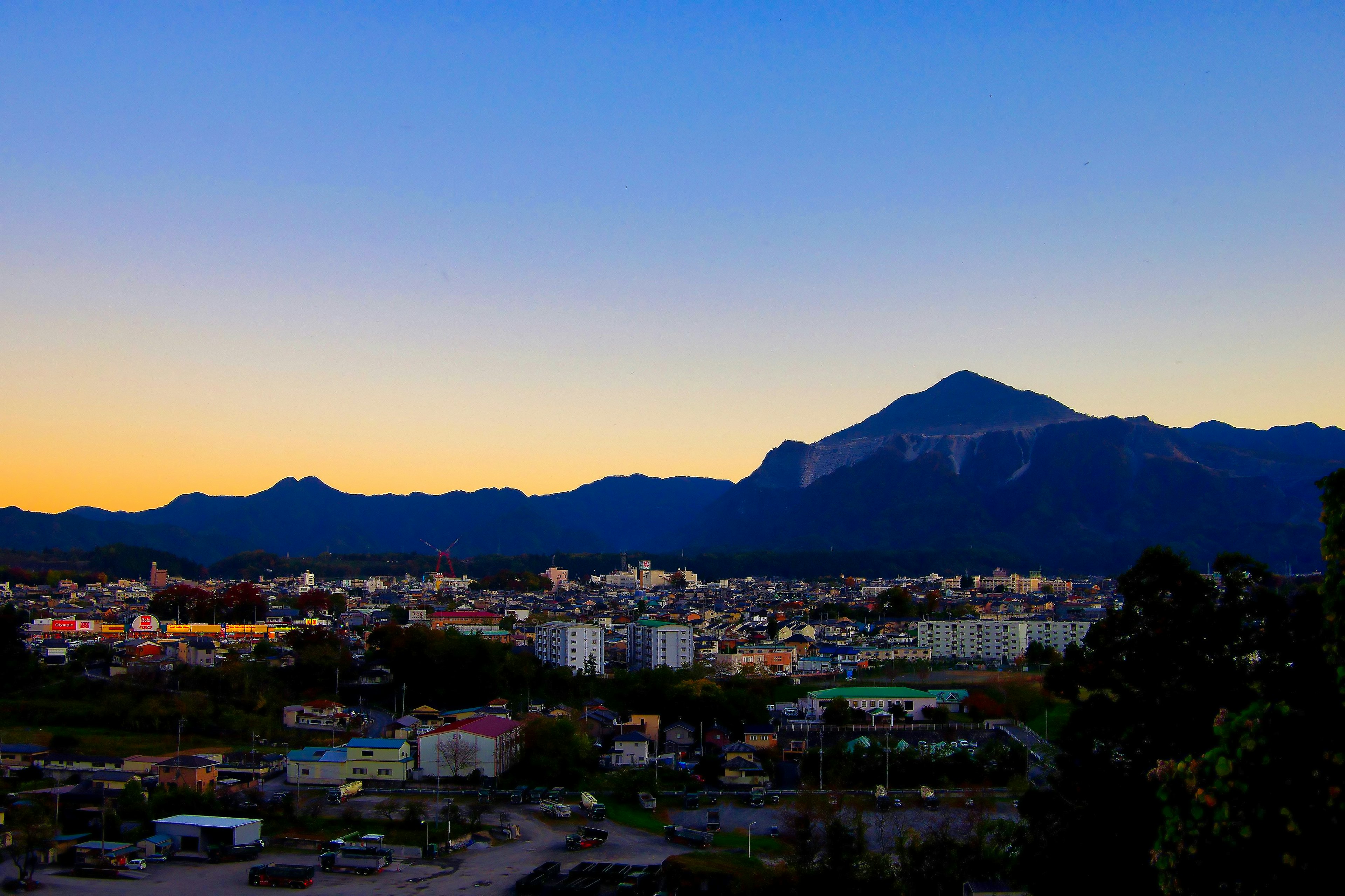 Stadtlandschaft mit Bergen und Sonnenuntergangshimmel