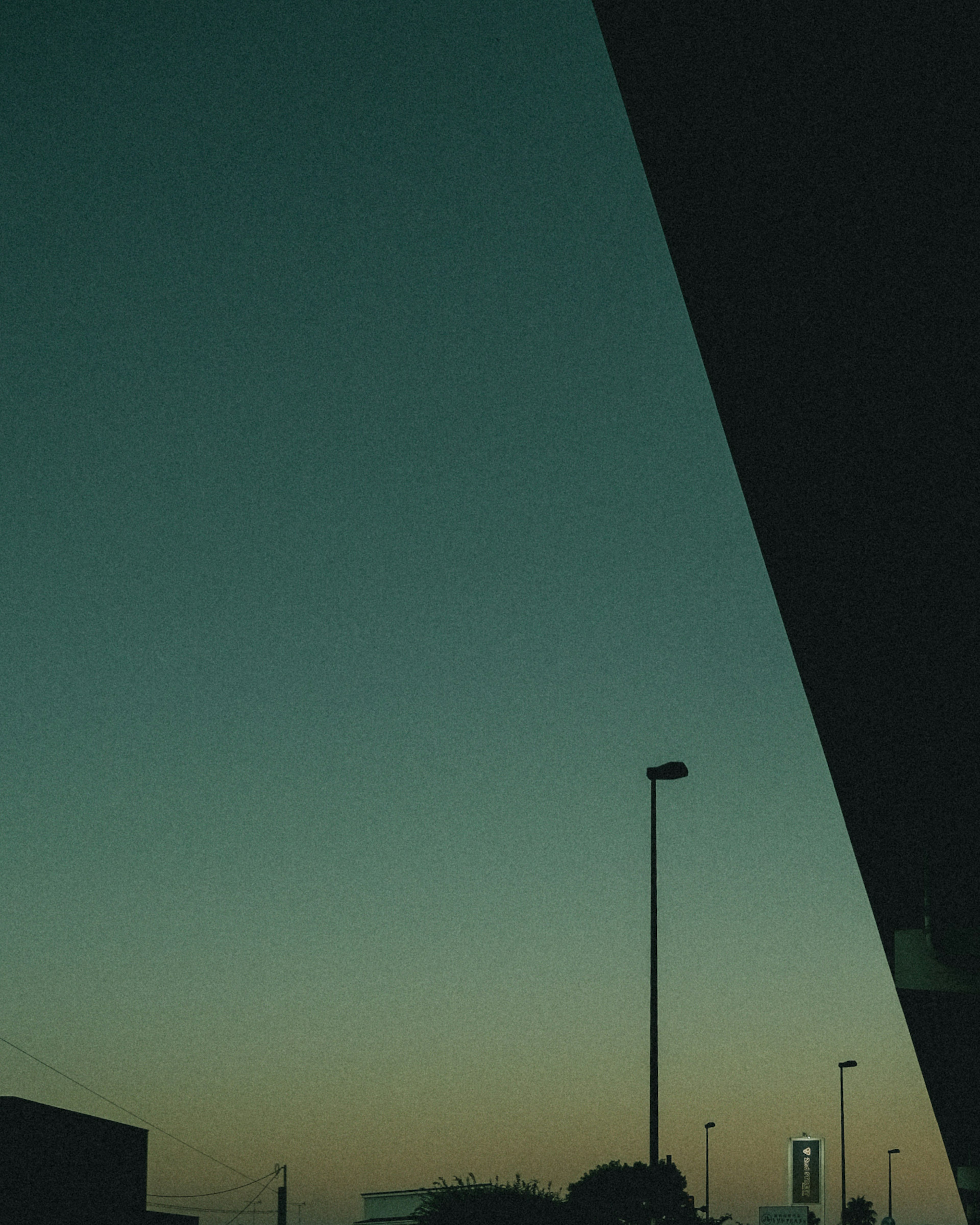 Ciel crépusculaire avec silhouette de bâtiment et lampadaire