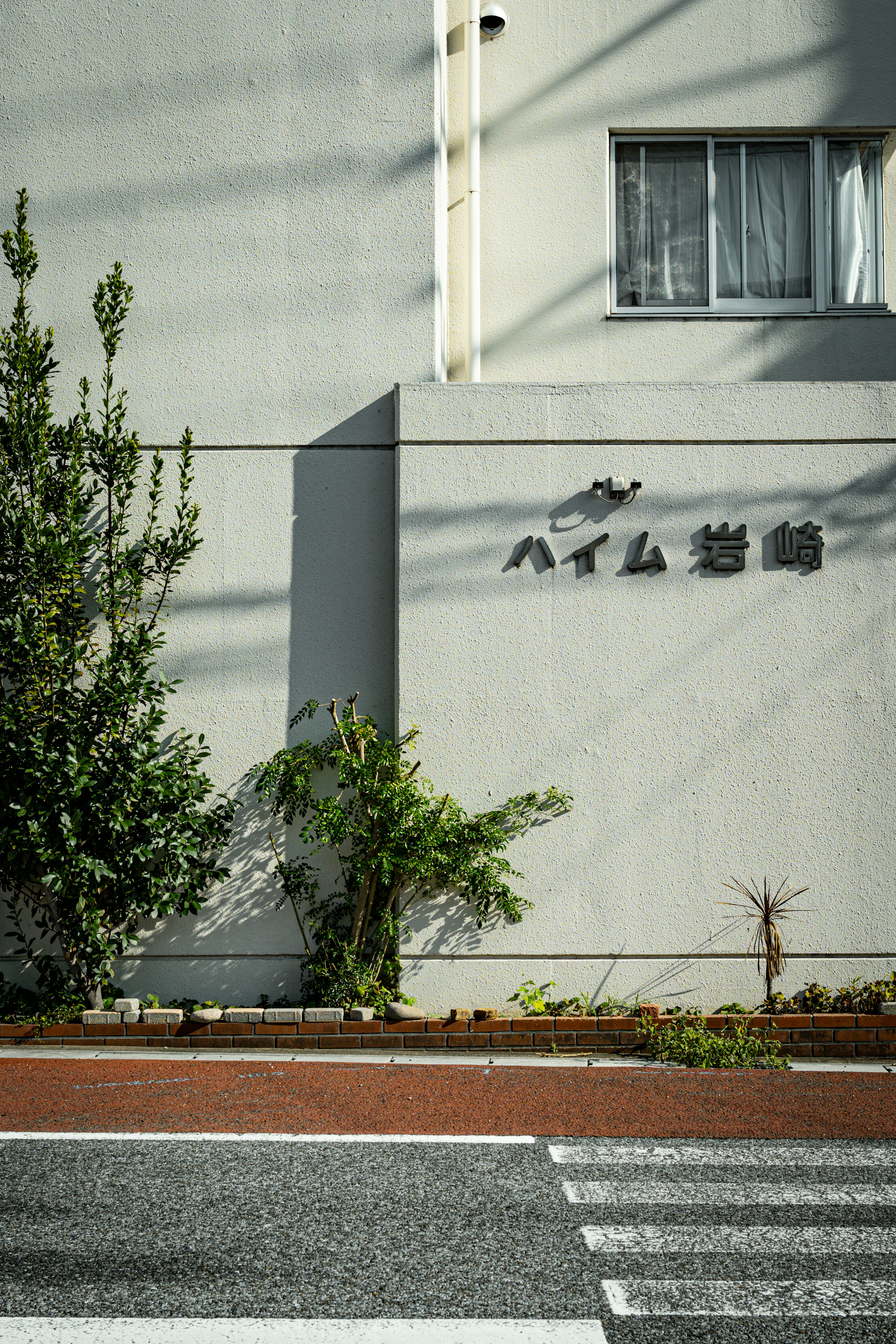 A building wall with a sign and surrounding greenery