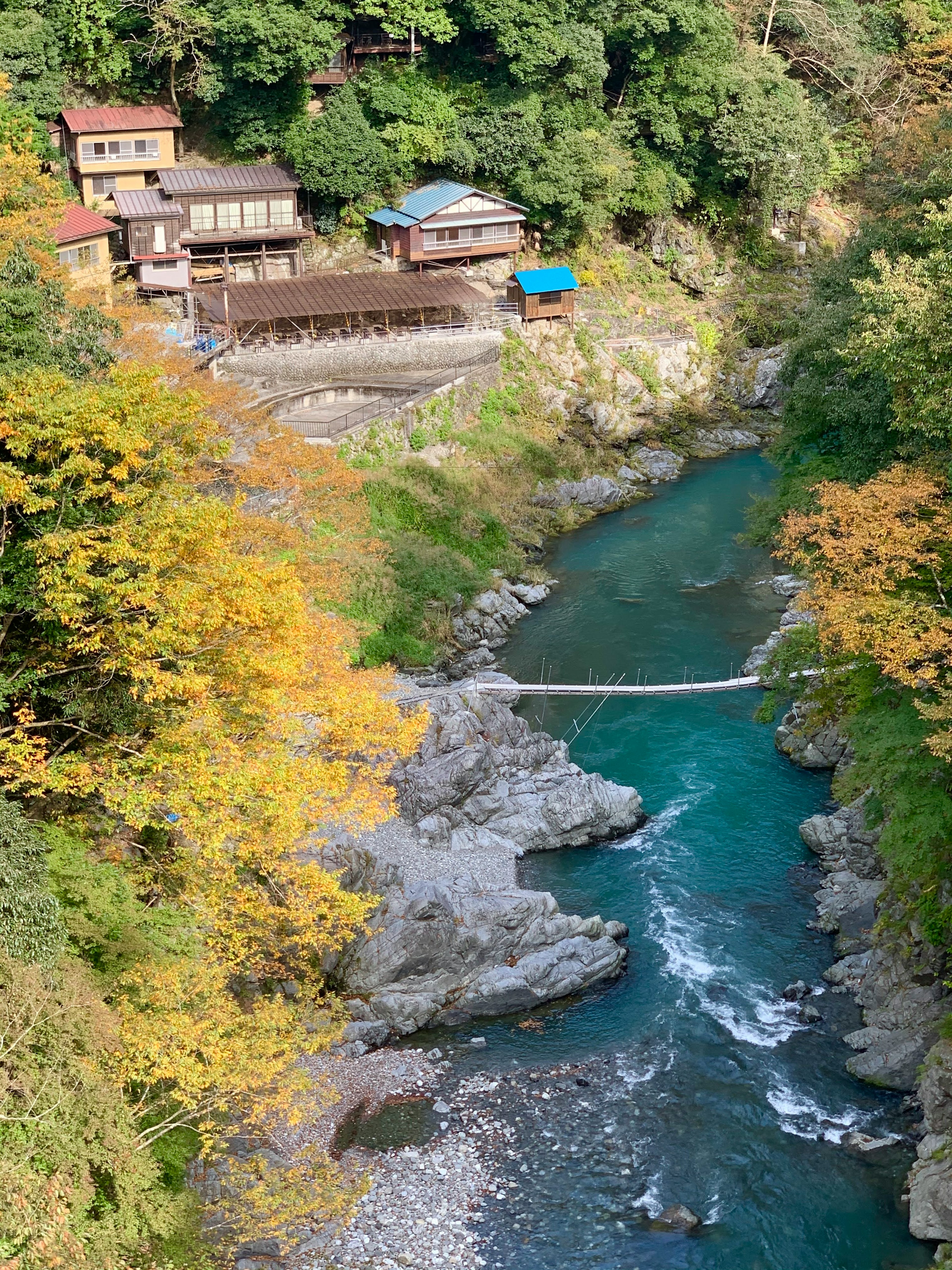 美しい渓谷と秋の紅葉の景色に囲まれた伝統的な建物と橋