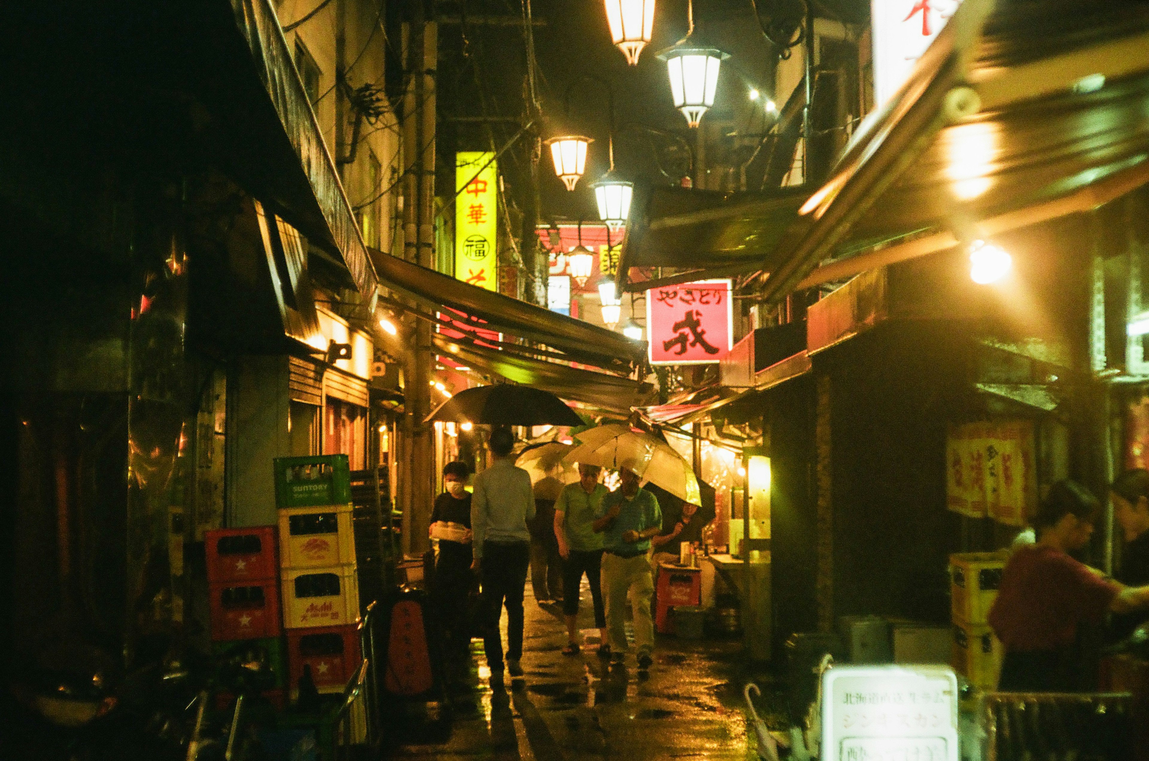 人们在夜间照亮的日本小巷中行走