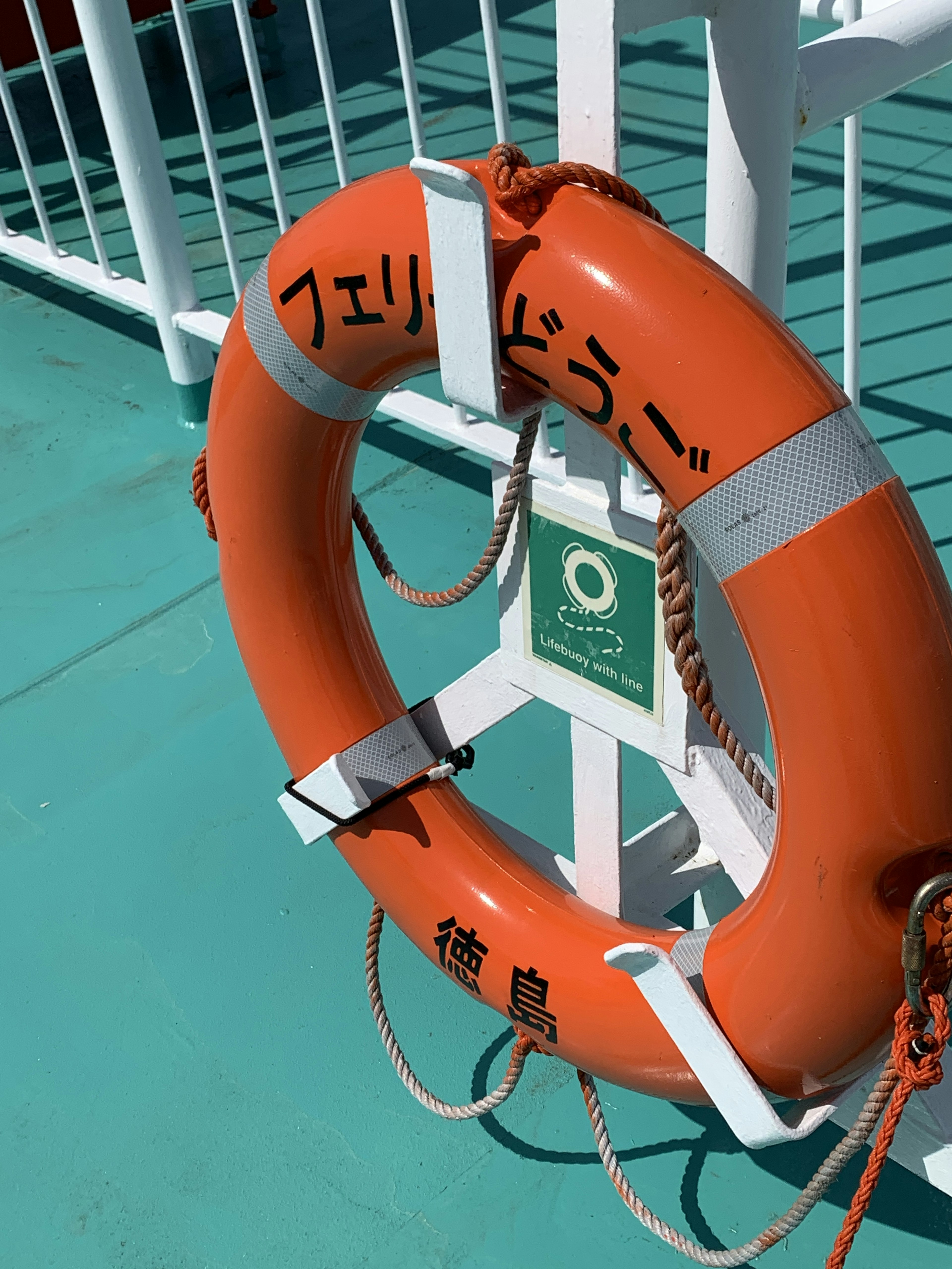 An orange lifesaver ring is placed on a ship's deck