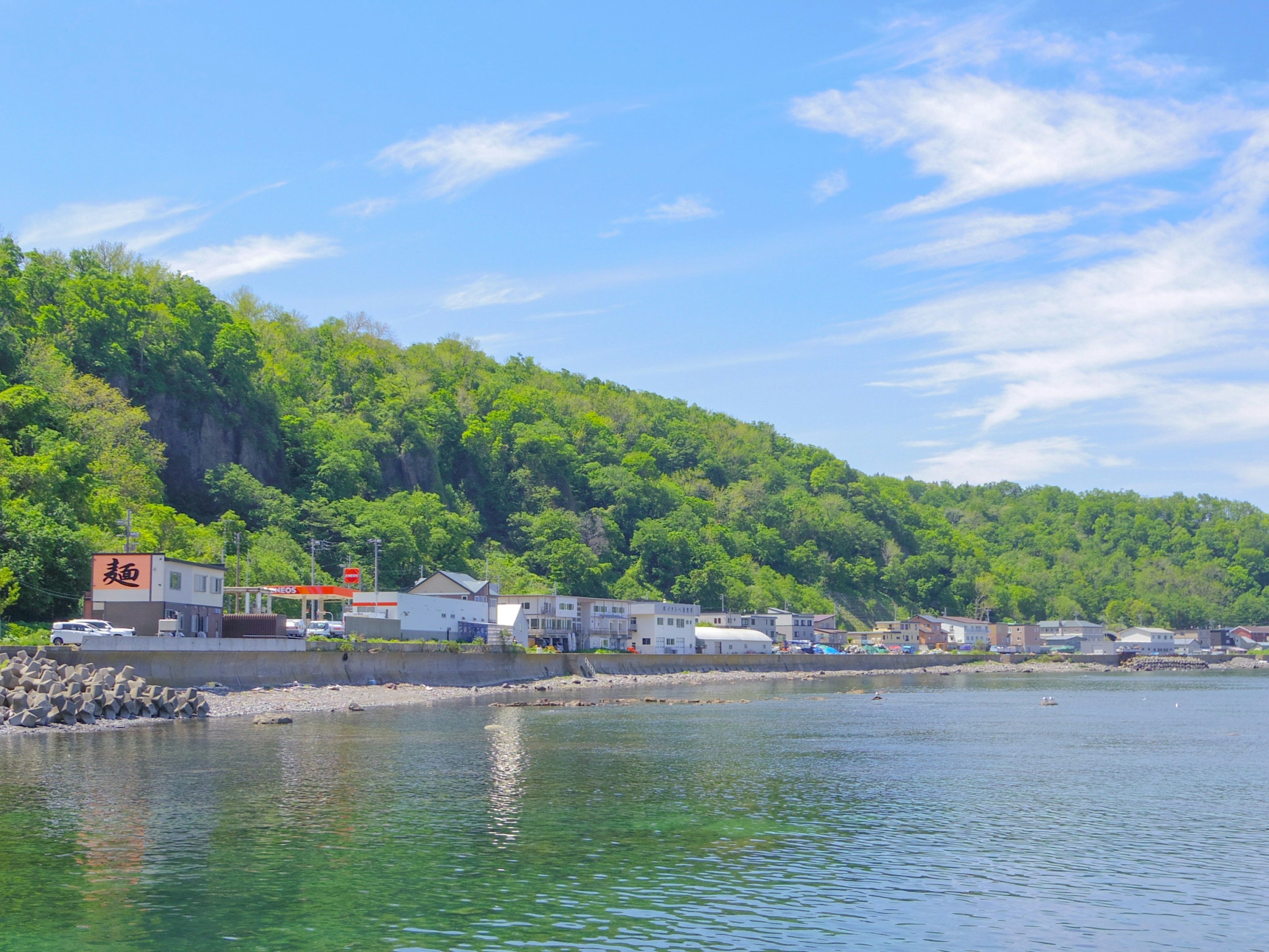 Vue pittoresque d'une ville côtière tranquille avec mer bleue et collines verdoyantes