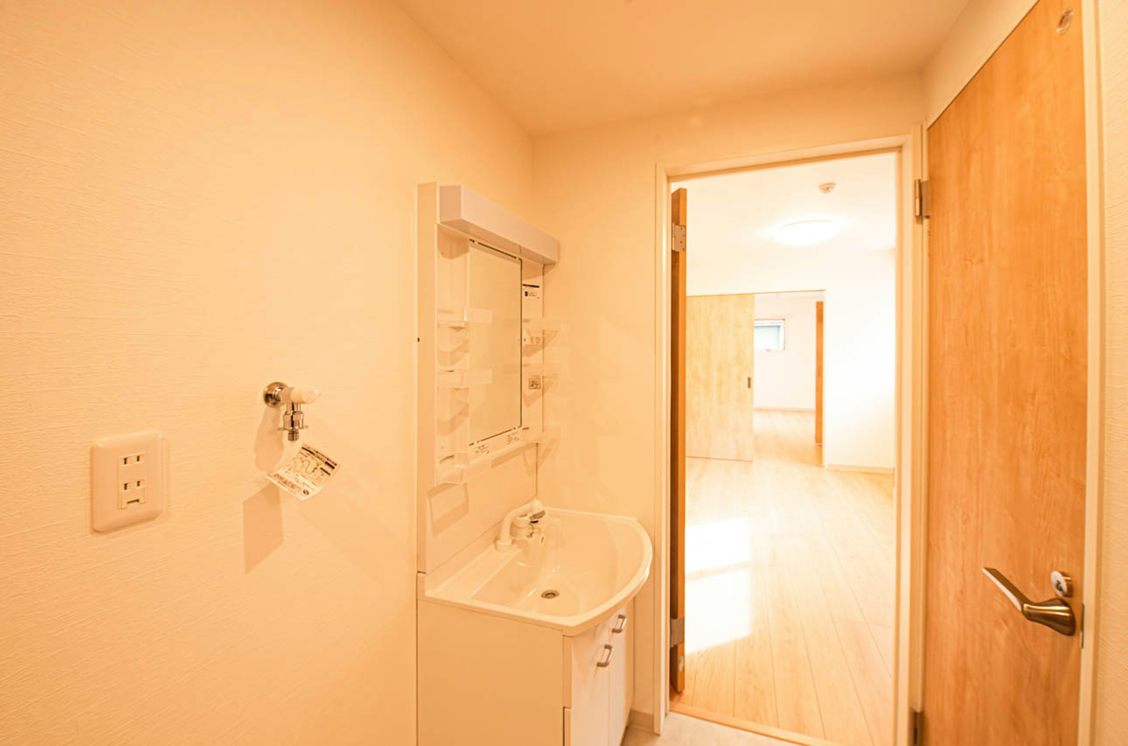 Petite salle de bain lumineuse avec un lavabo et une porte ouverte