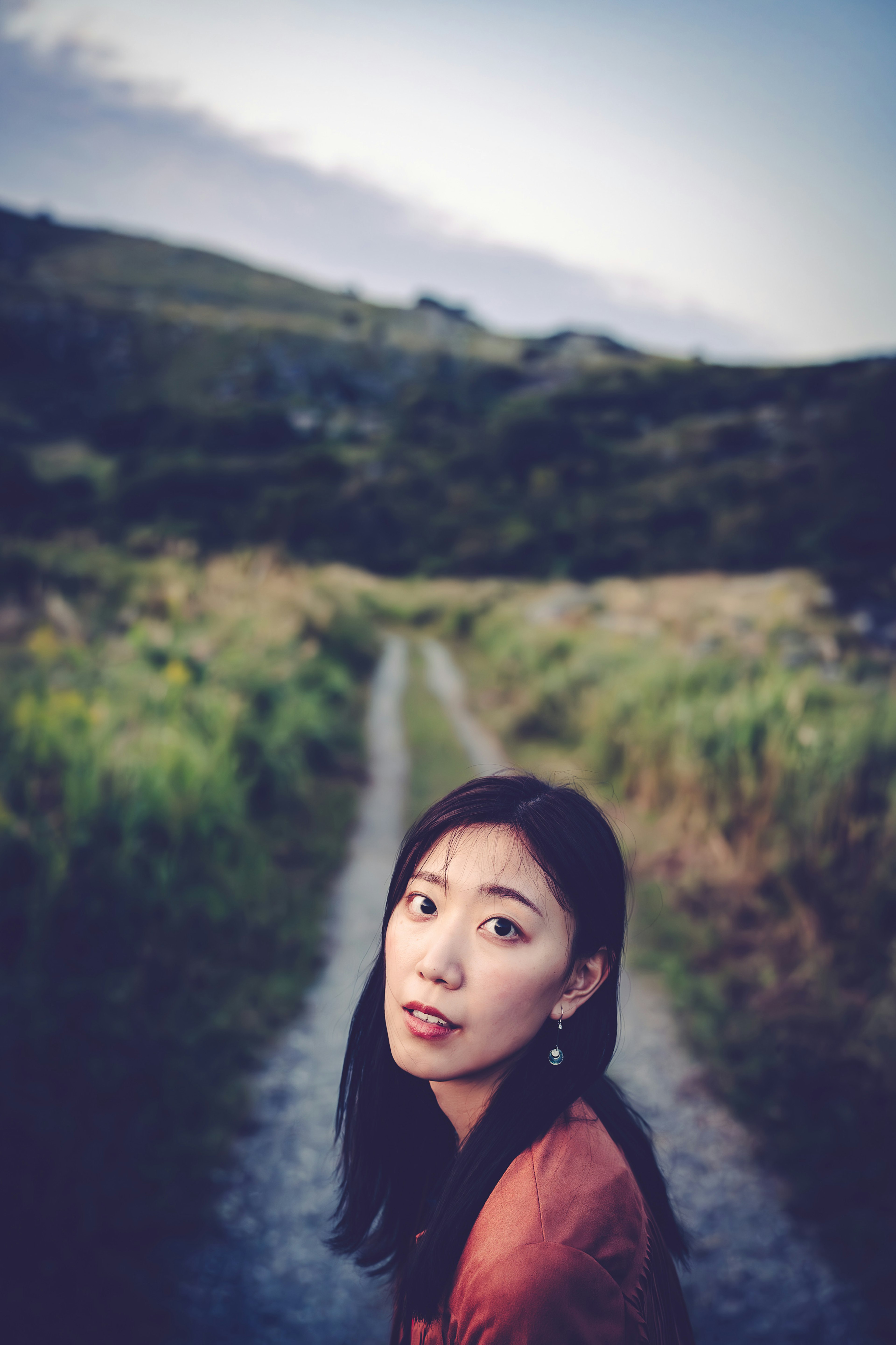 Portrait of a woman looking back on a twilight path