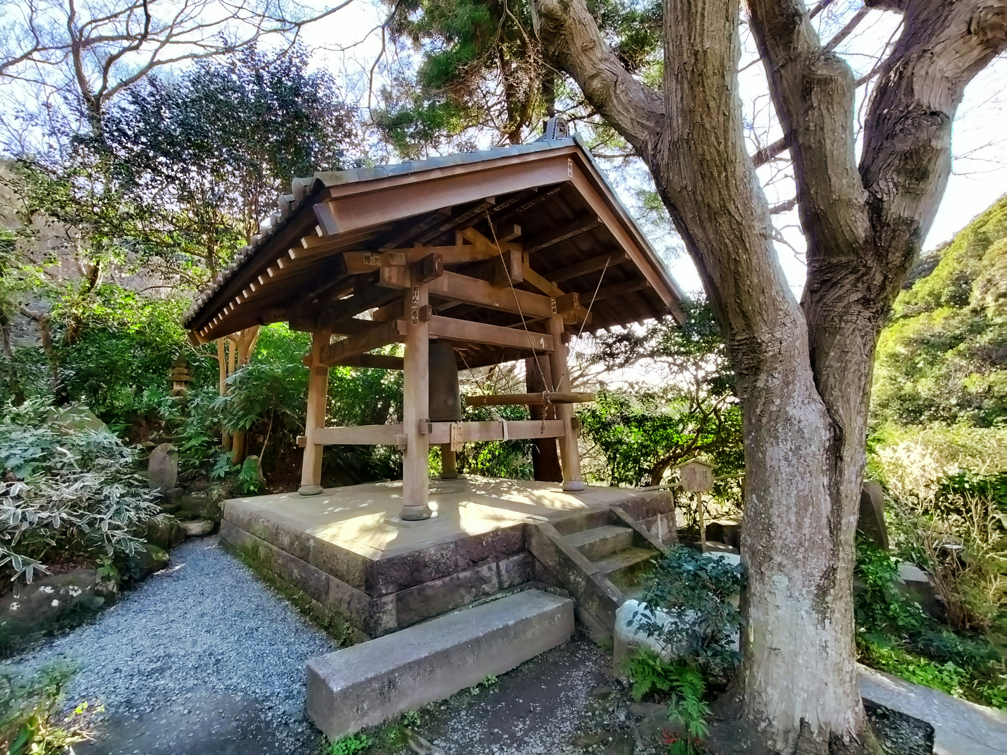 Traditional wooden bell tower standing in a serene garden