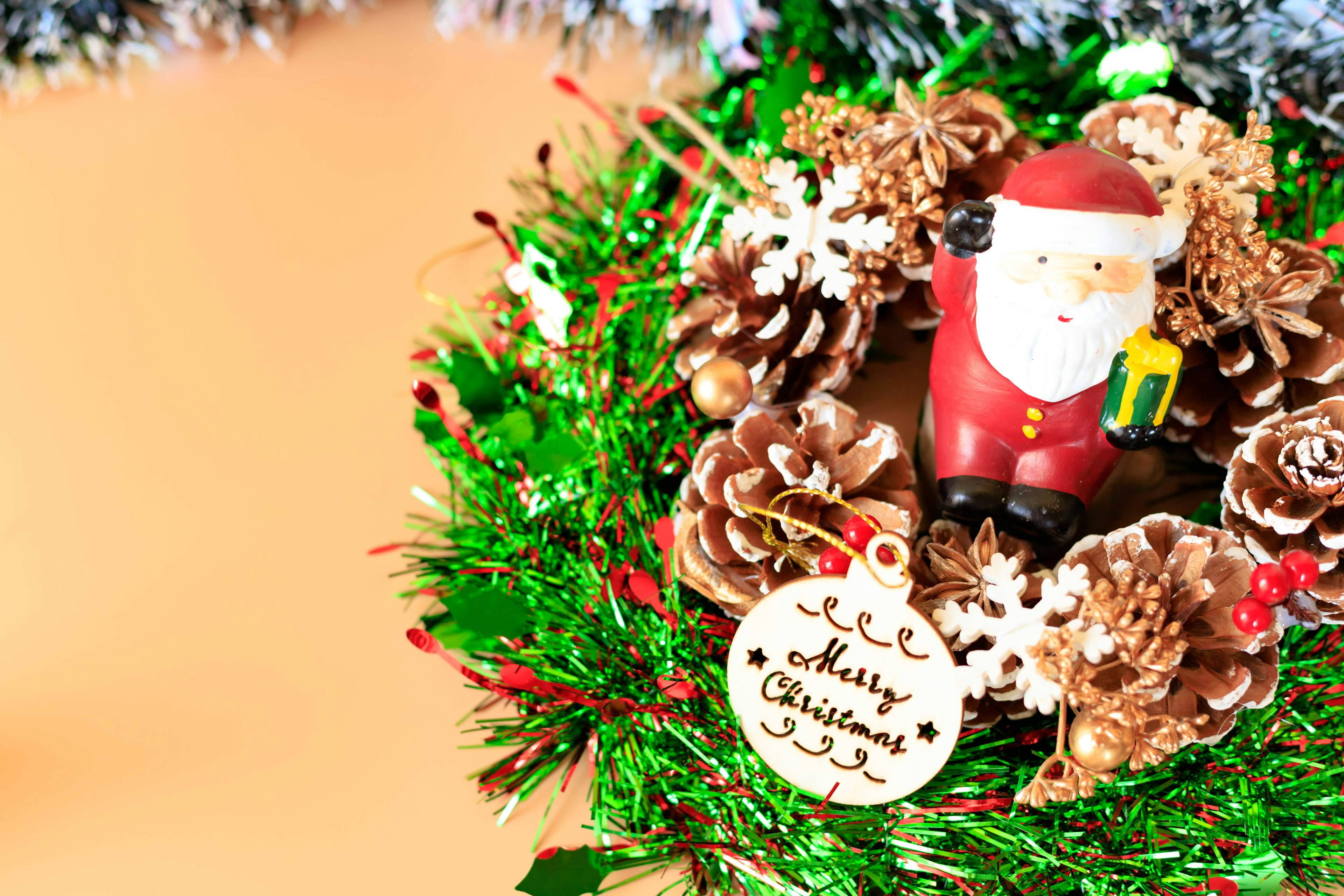 Christmas wreath featuring a Santa figurine and pine cones