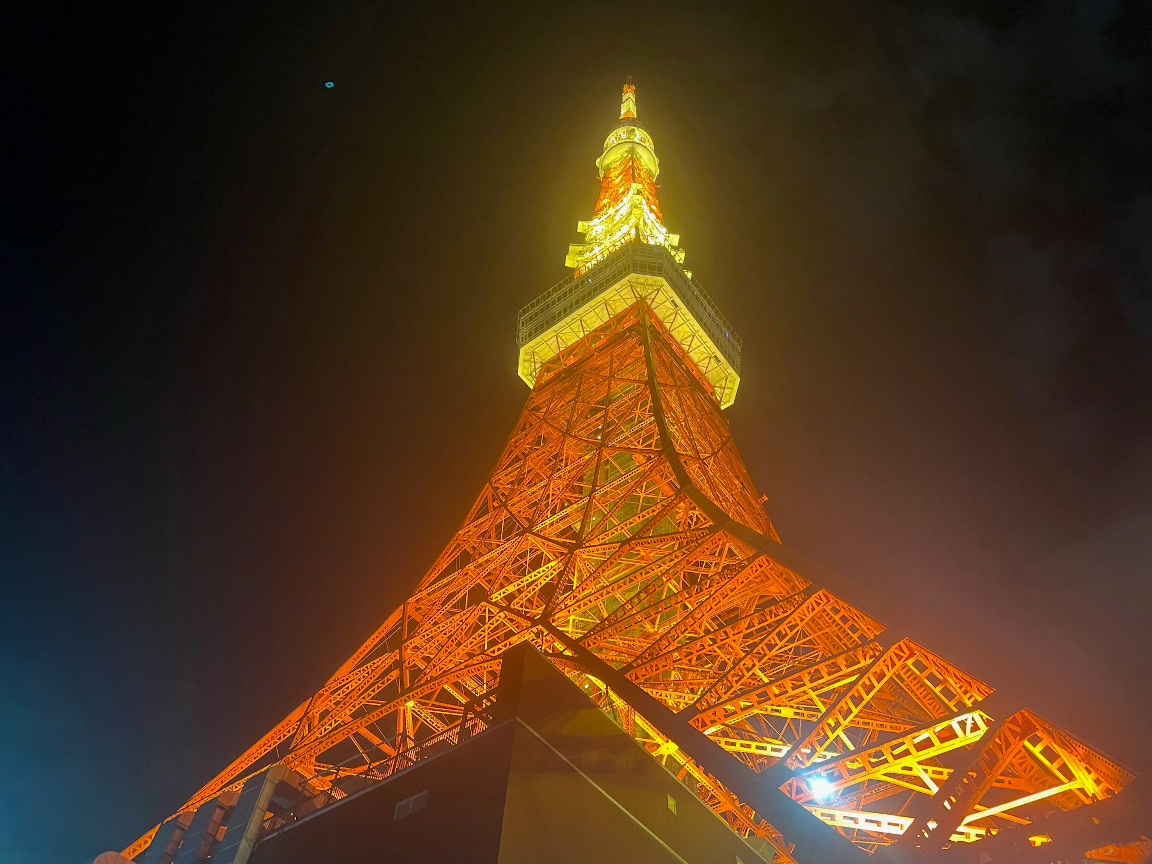 Pemandangan Menara Tokyo di malam hari dari bawah Struktur oranye terang