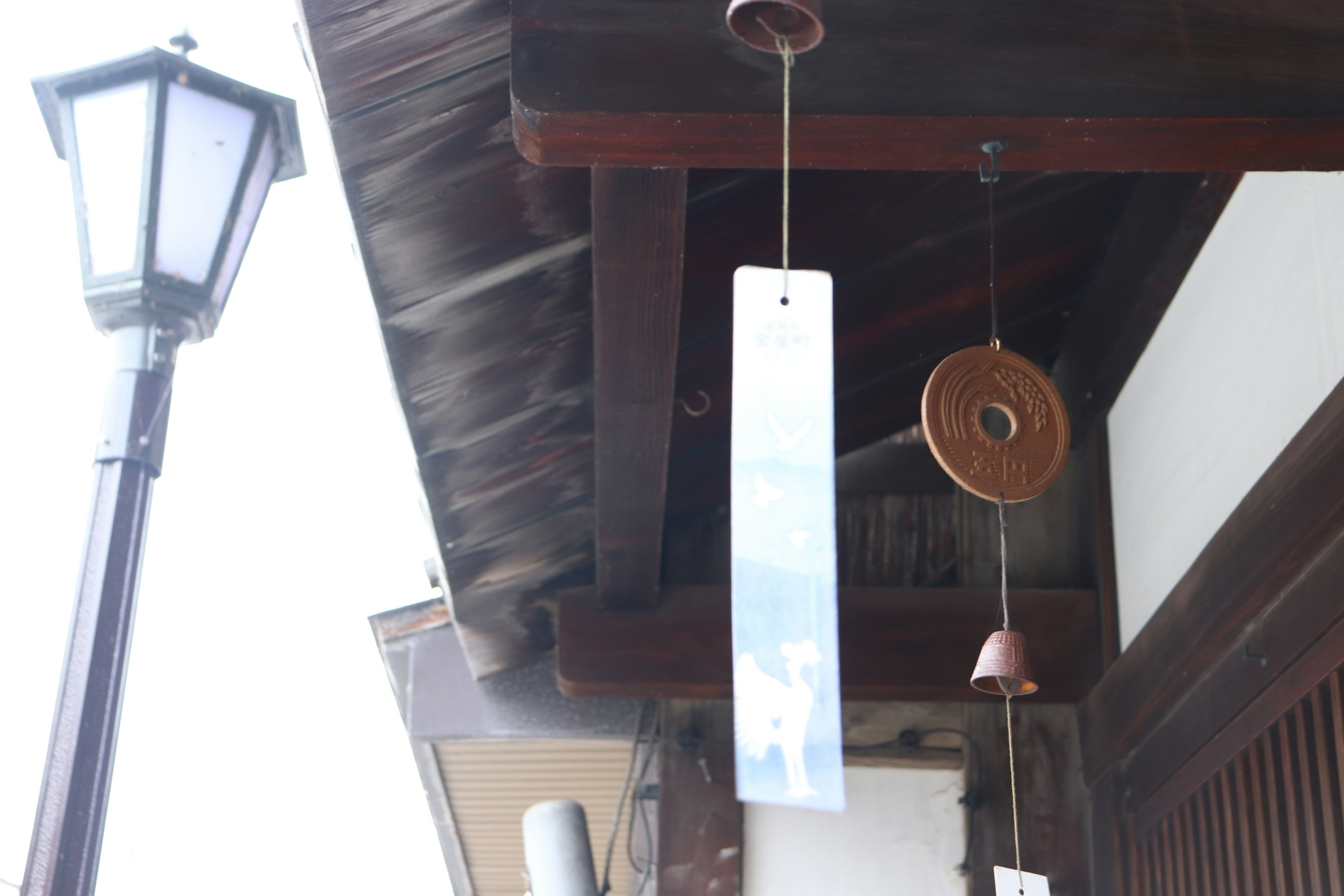 Traditional building exterior with wind chimes and street lamp