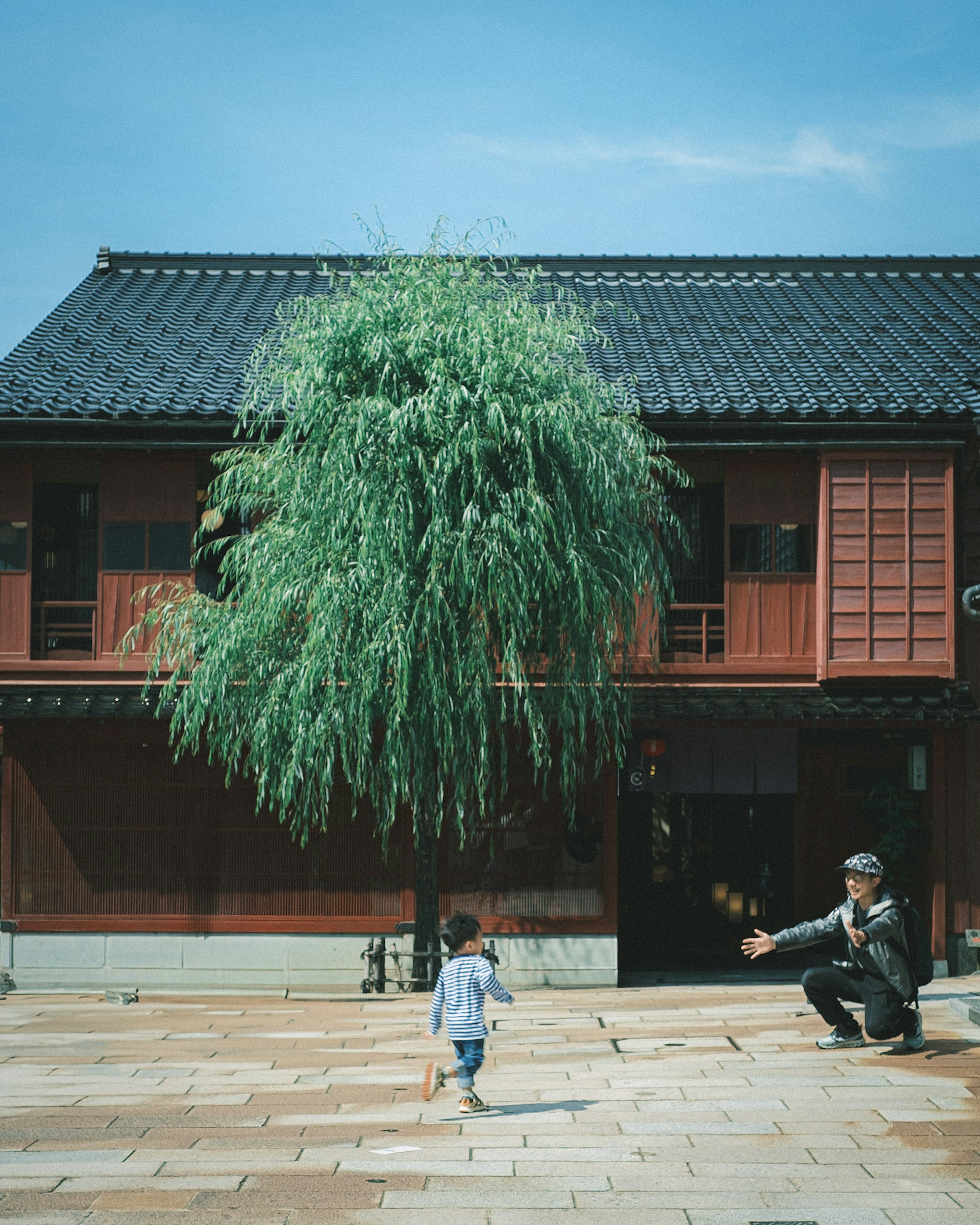 孩子跑向房子，成人伸出雙臂