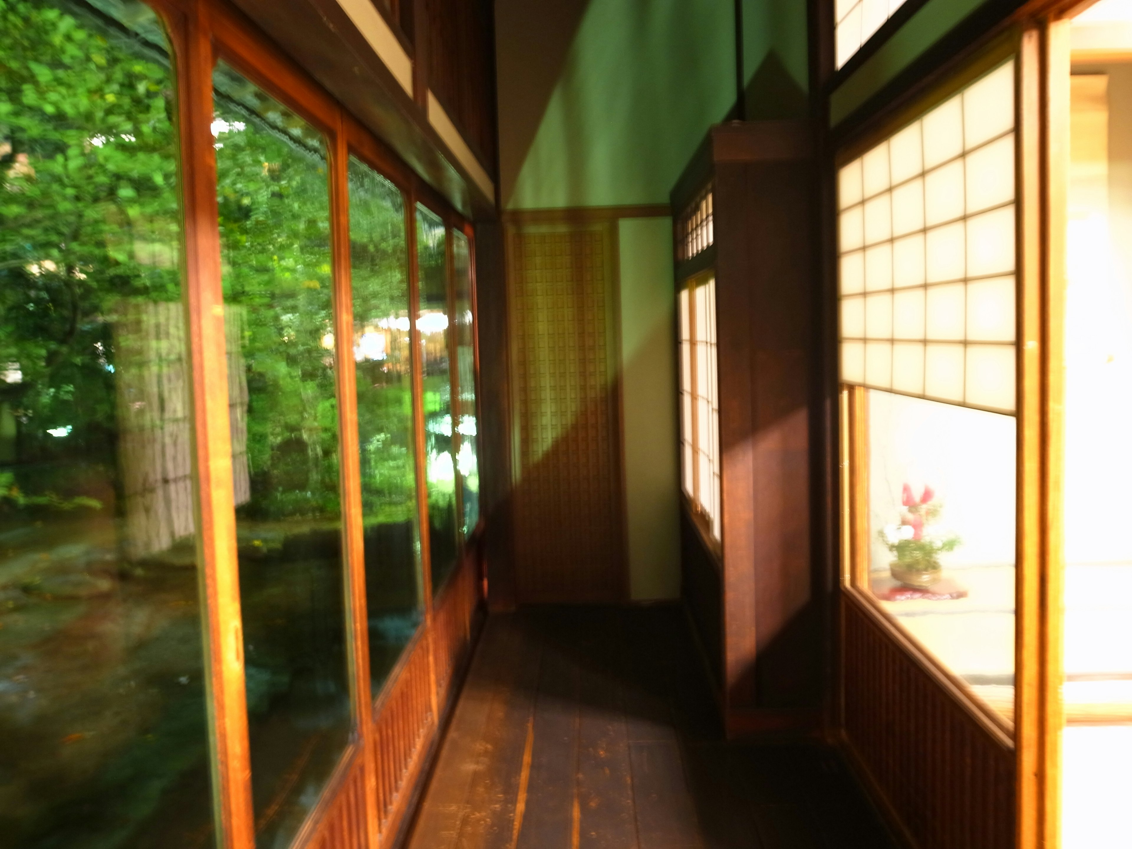 Couloir en bois avec des fenêtres laissant entrer la lumière naturelle dans une pièce japonaise traditionnelle