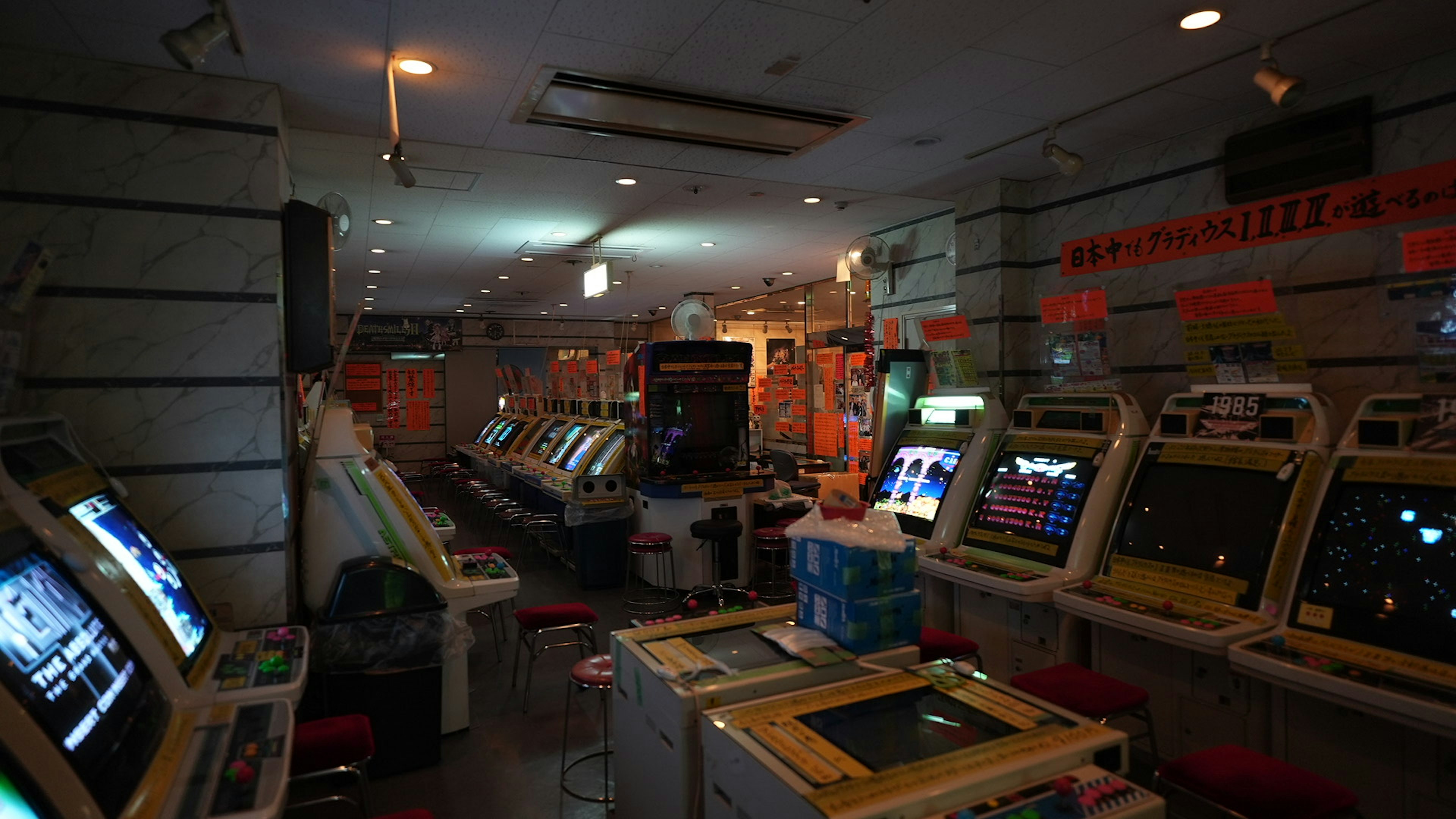 Interior de una sala de arcade poco iluminada llena de máquinas de juego