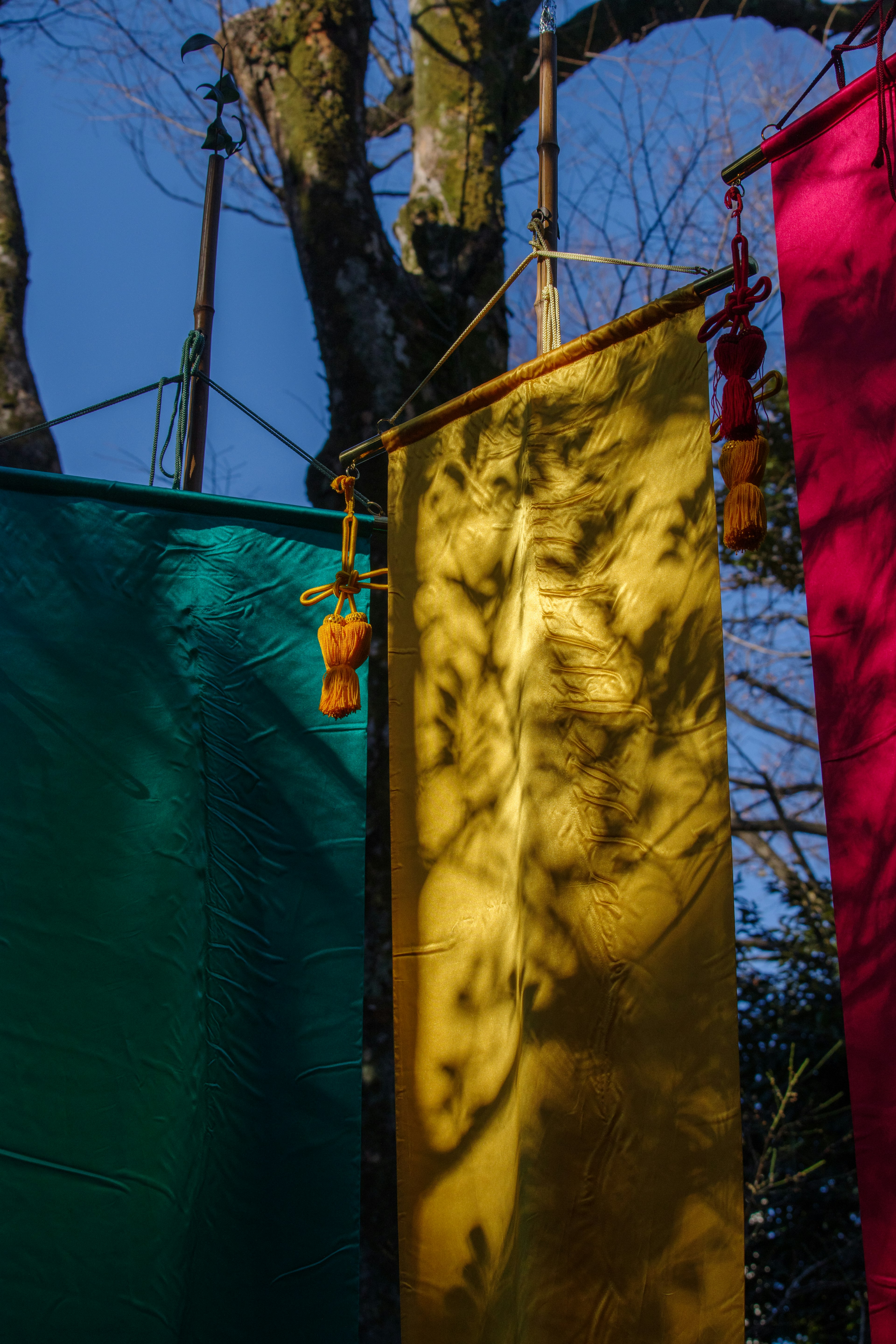 Bandiere di stoffa colorate appese sotto un cielo blu con ombre