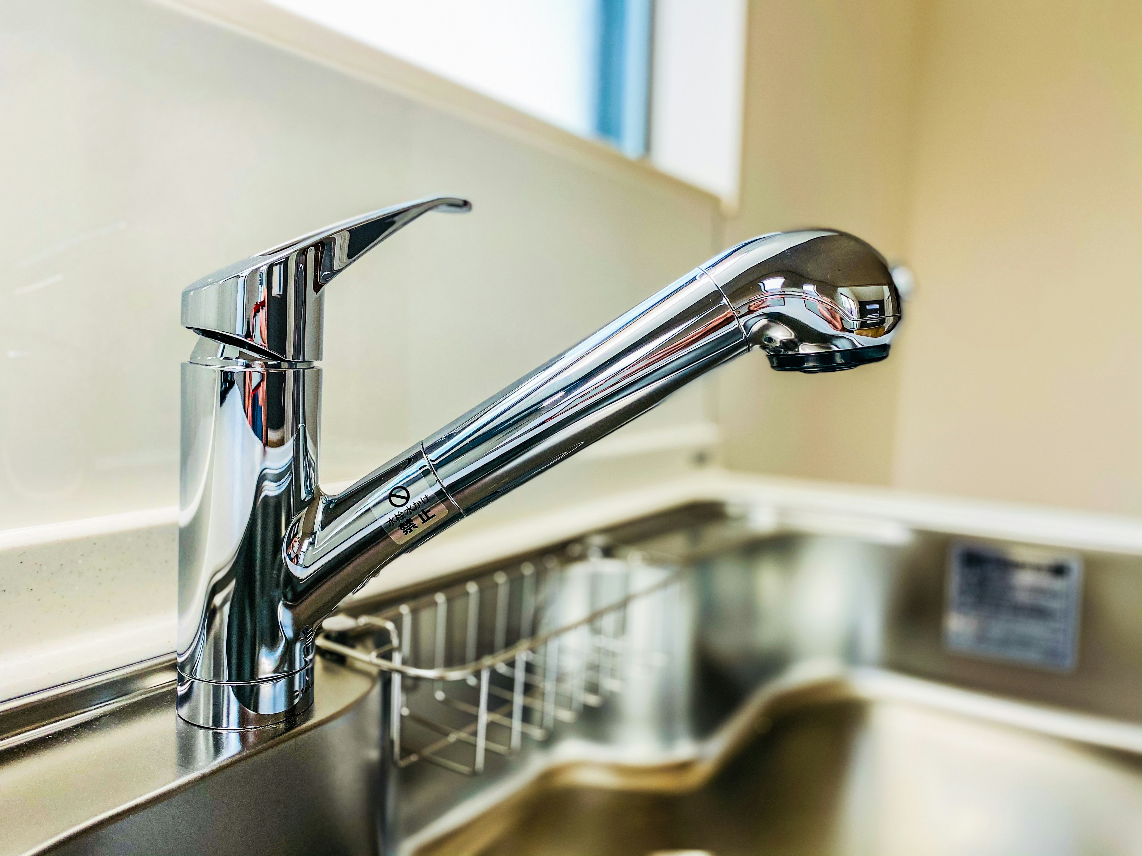 Shiny metal kitchen faucet mounted on a sink