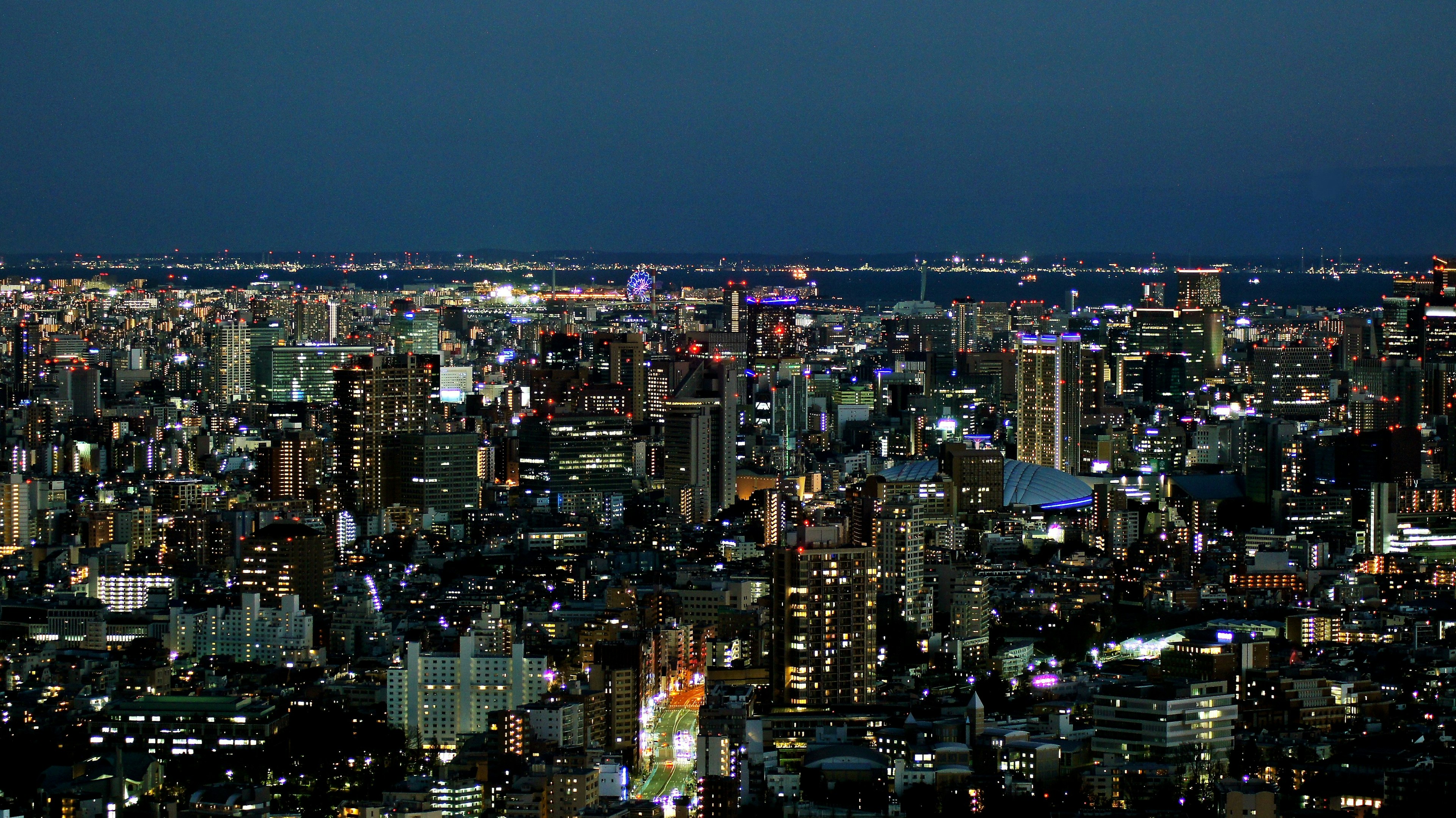 Vue nocturne de la ville avec des gratte-ciels illuminés et des lumières vives