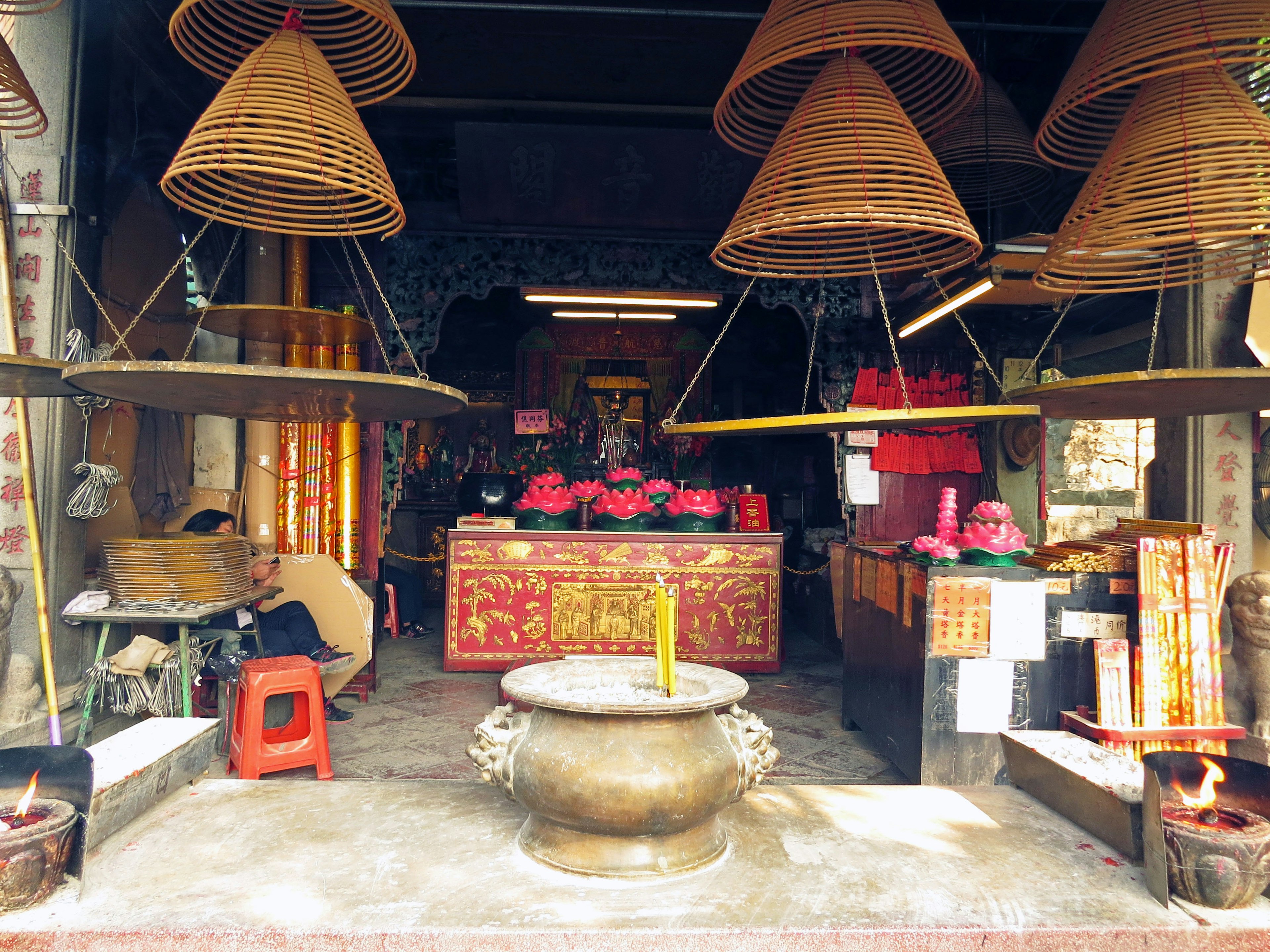 Traditional temple interior featuring incense burners and large coils of incense