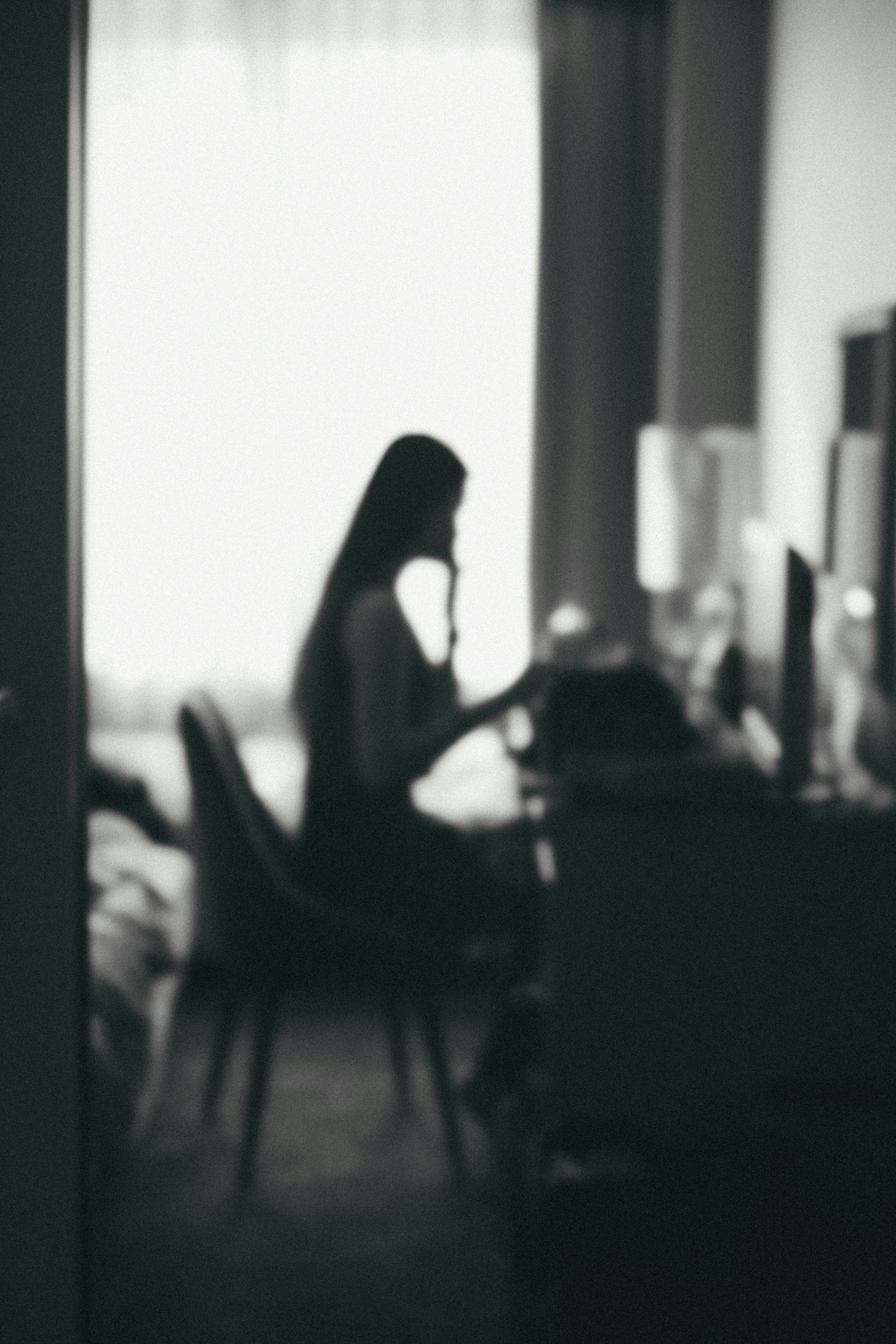 Blurred silhouette of a woman working at a desk