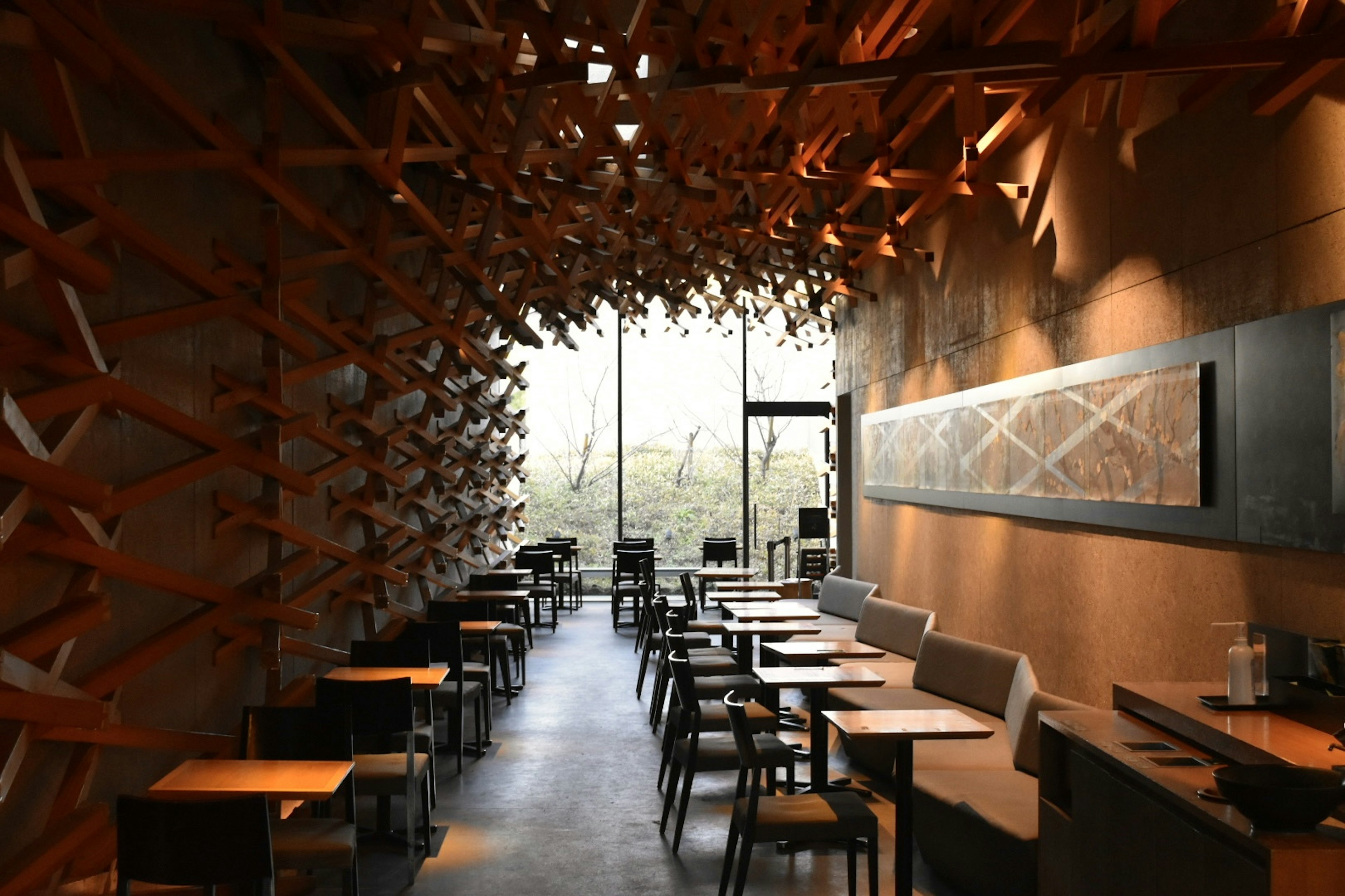 Interior de restaurante moderno con decoración de madera y grandes ventanas luminosas