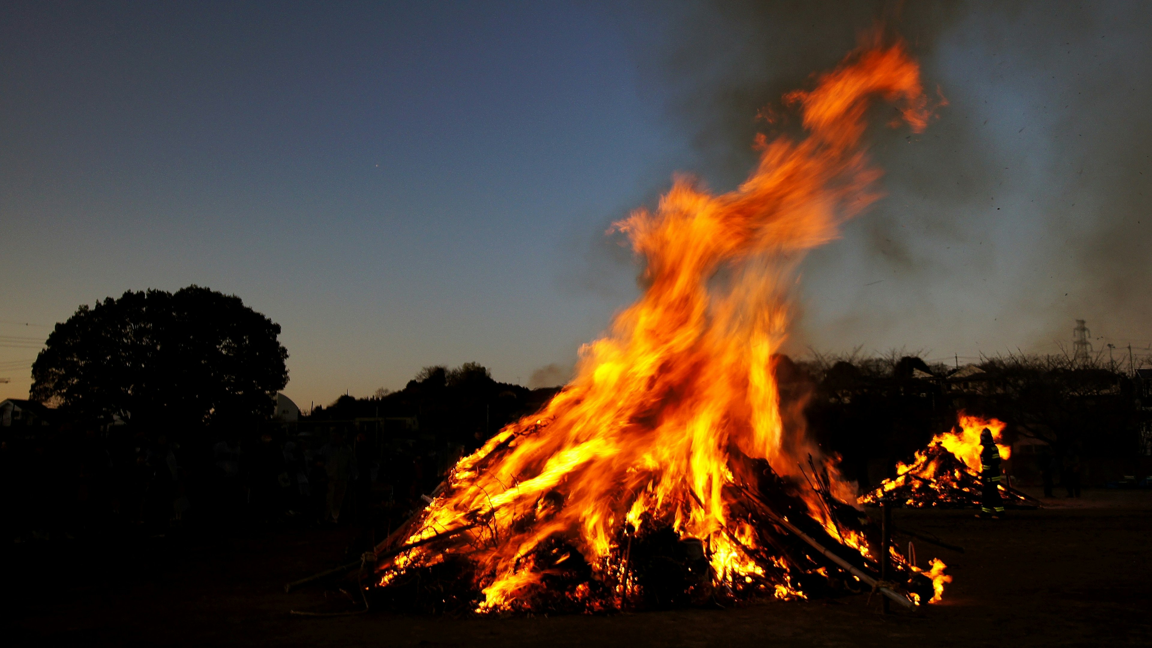 Un grande falò che brucia al crepuscolo con fiamme vivaci