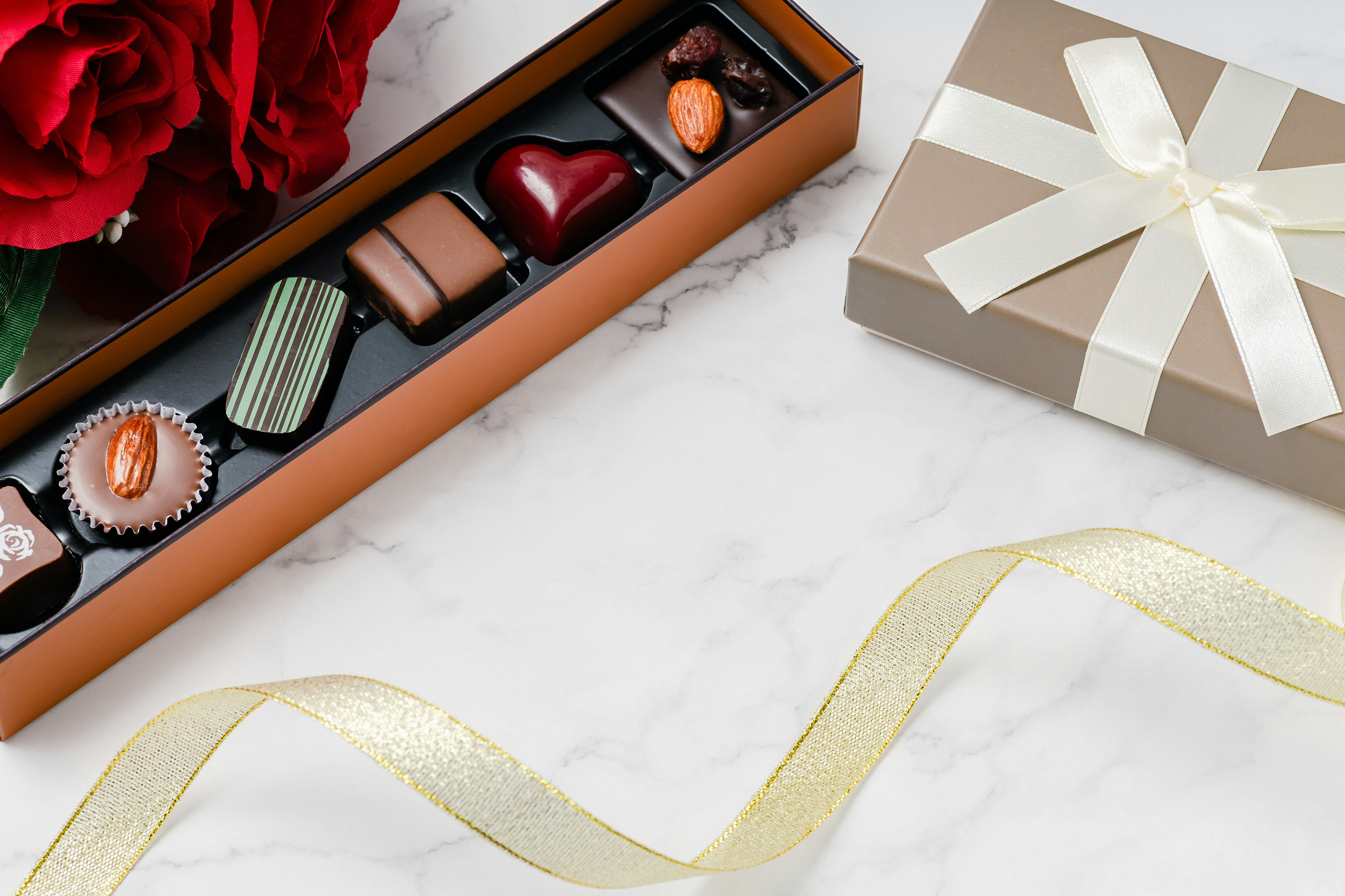 Elegant arrangement of chocolates in a box with a red rose