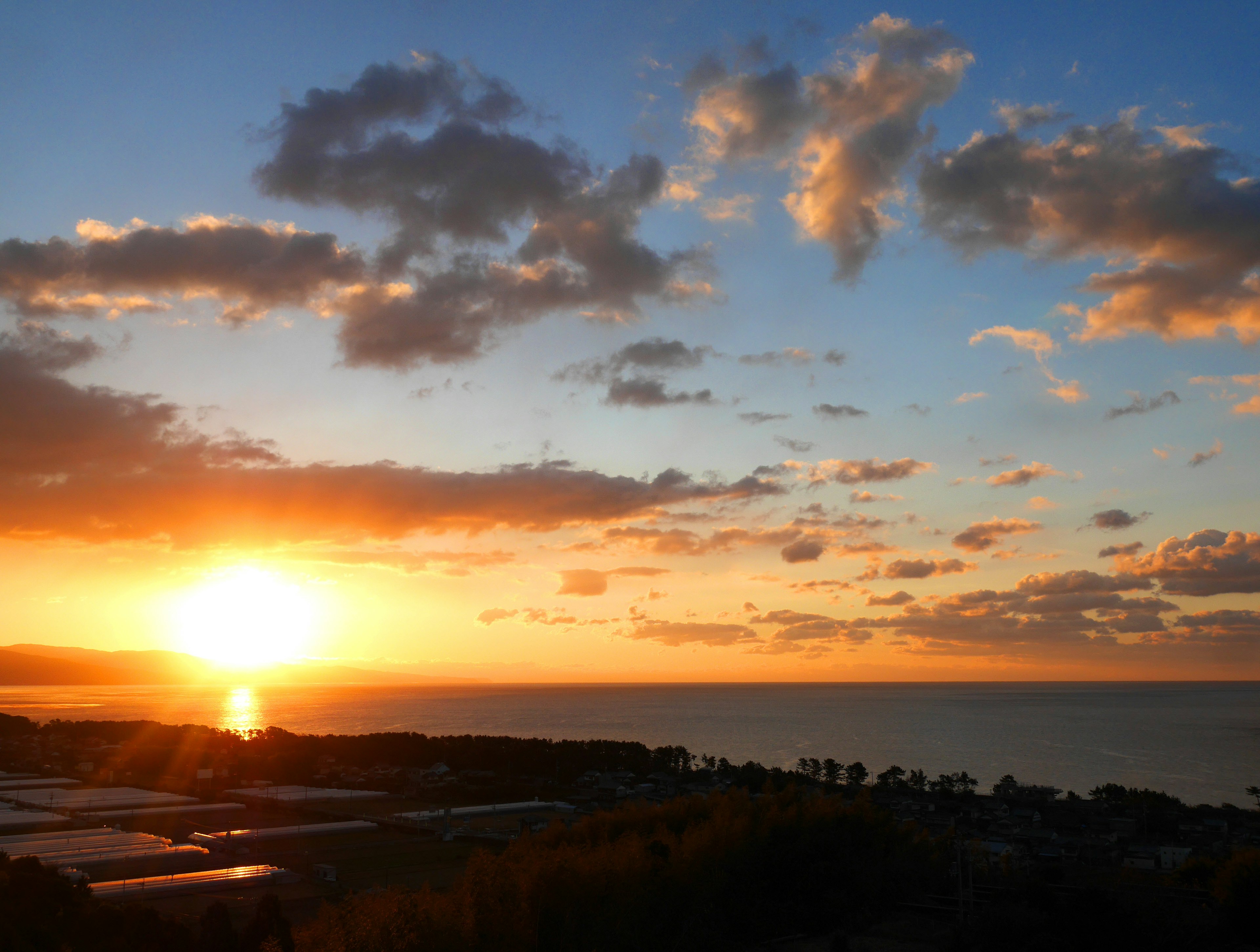 Schöner Sonnenuntergang über dem Ozean mit orangefarbenem Himmel und Wolken