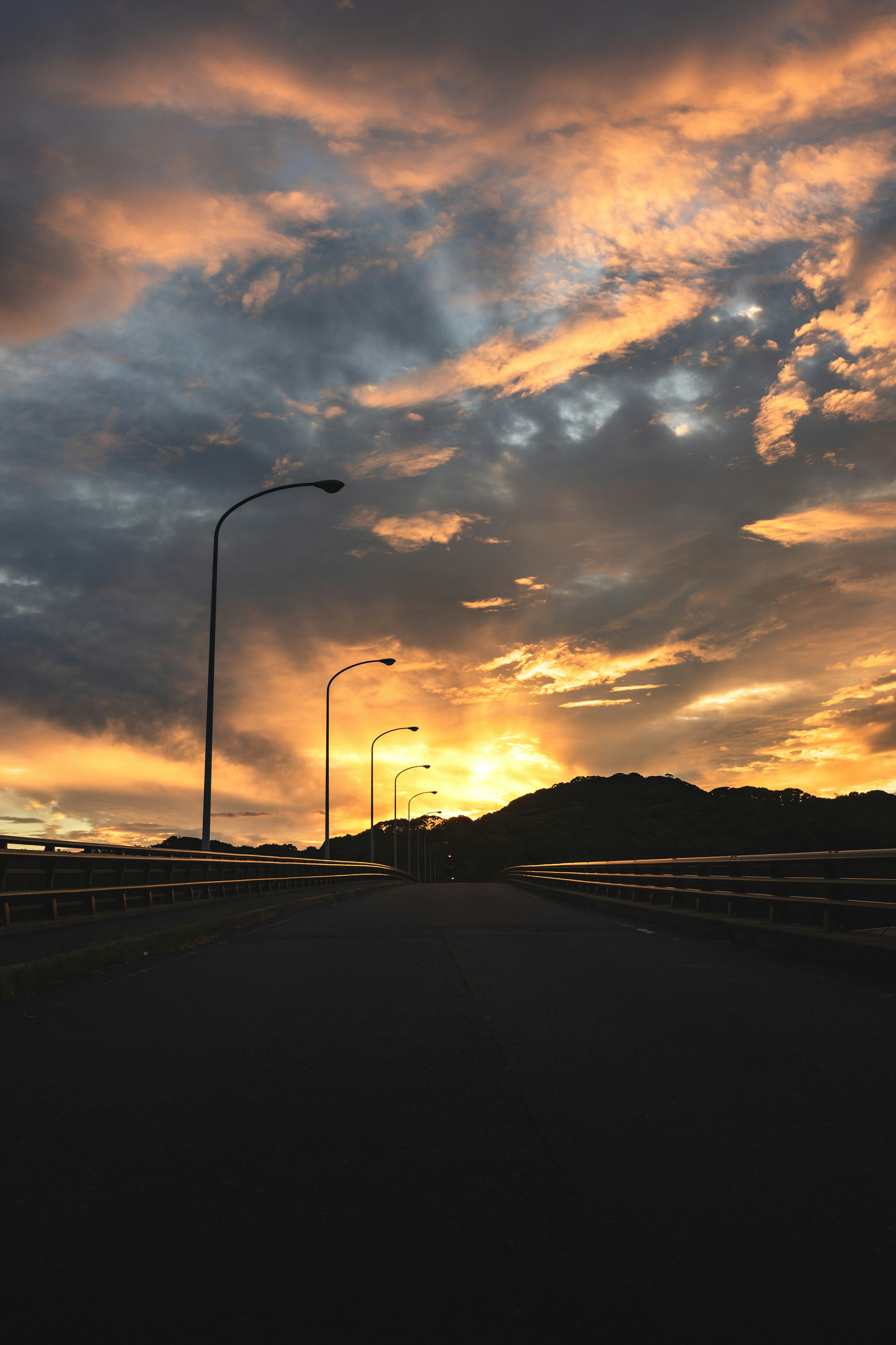 Dramatic sunset with vibrant clouds over a silhouetted road