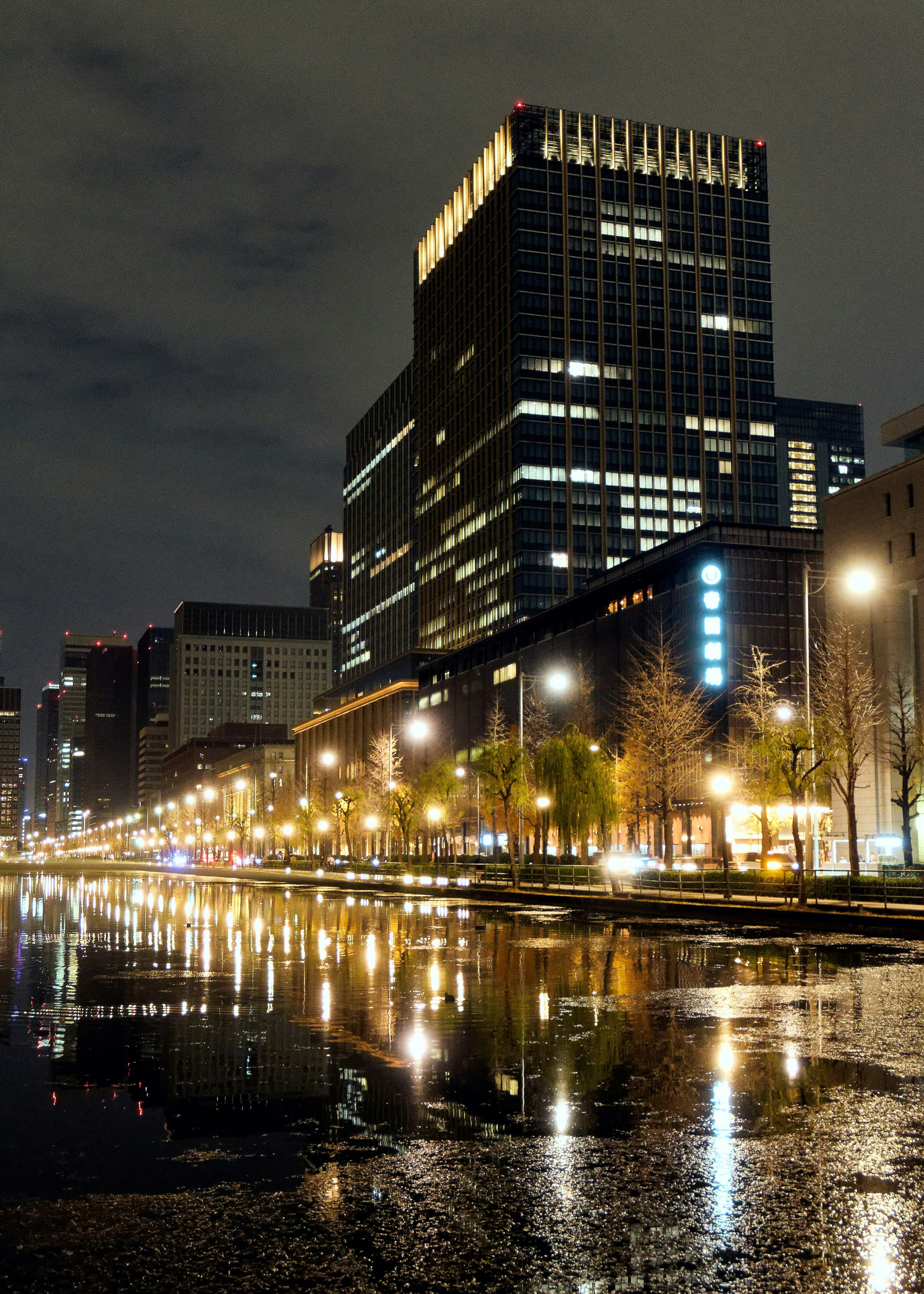 Paisaje urbano nocturno con rascacielos y reflejos en el agua