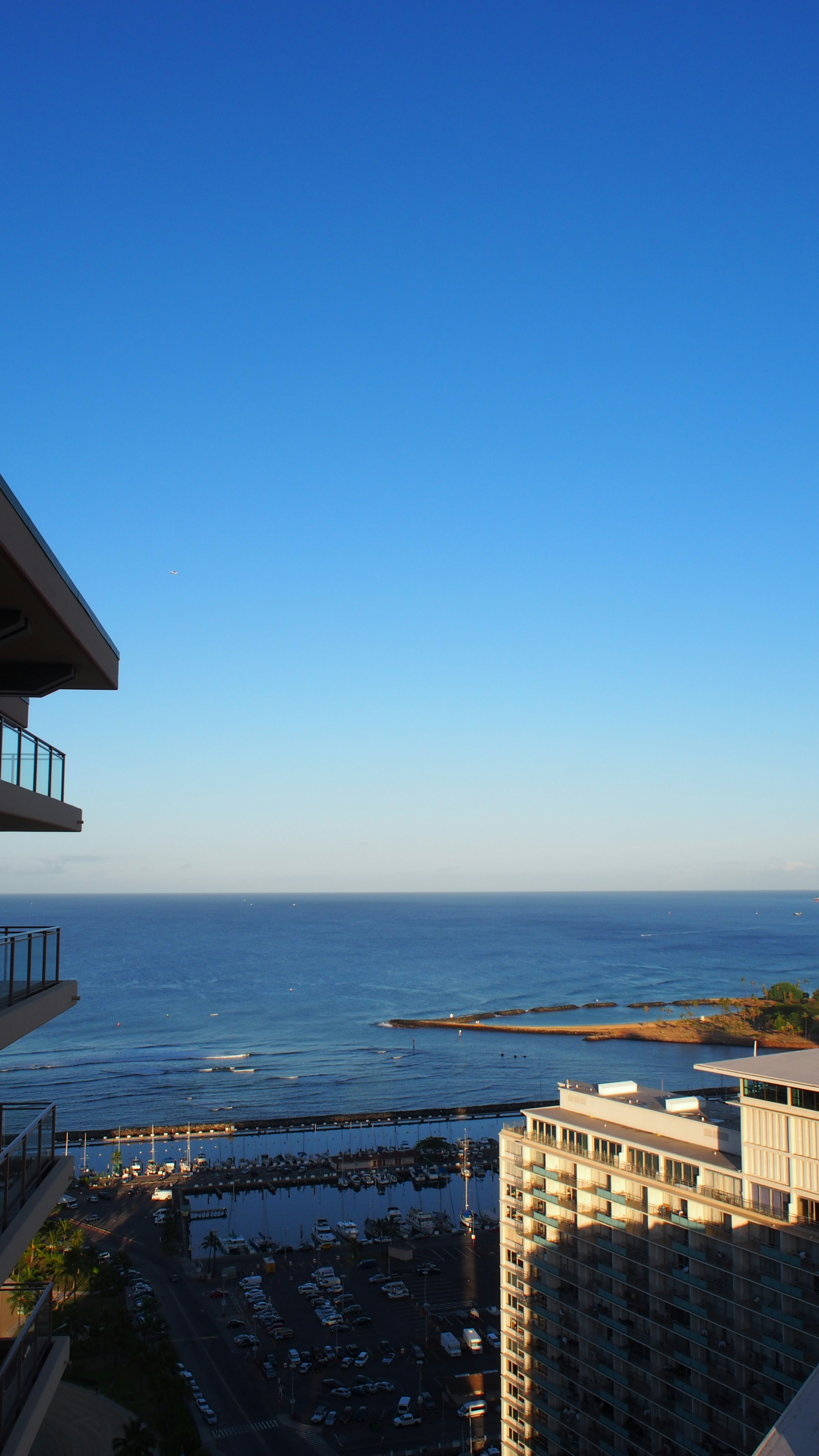 Pemandangan langit biru dan laut dari balkon gedung tinggi