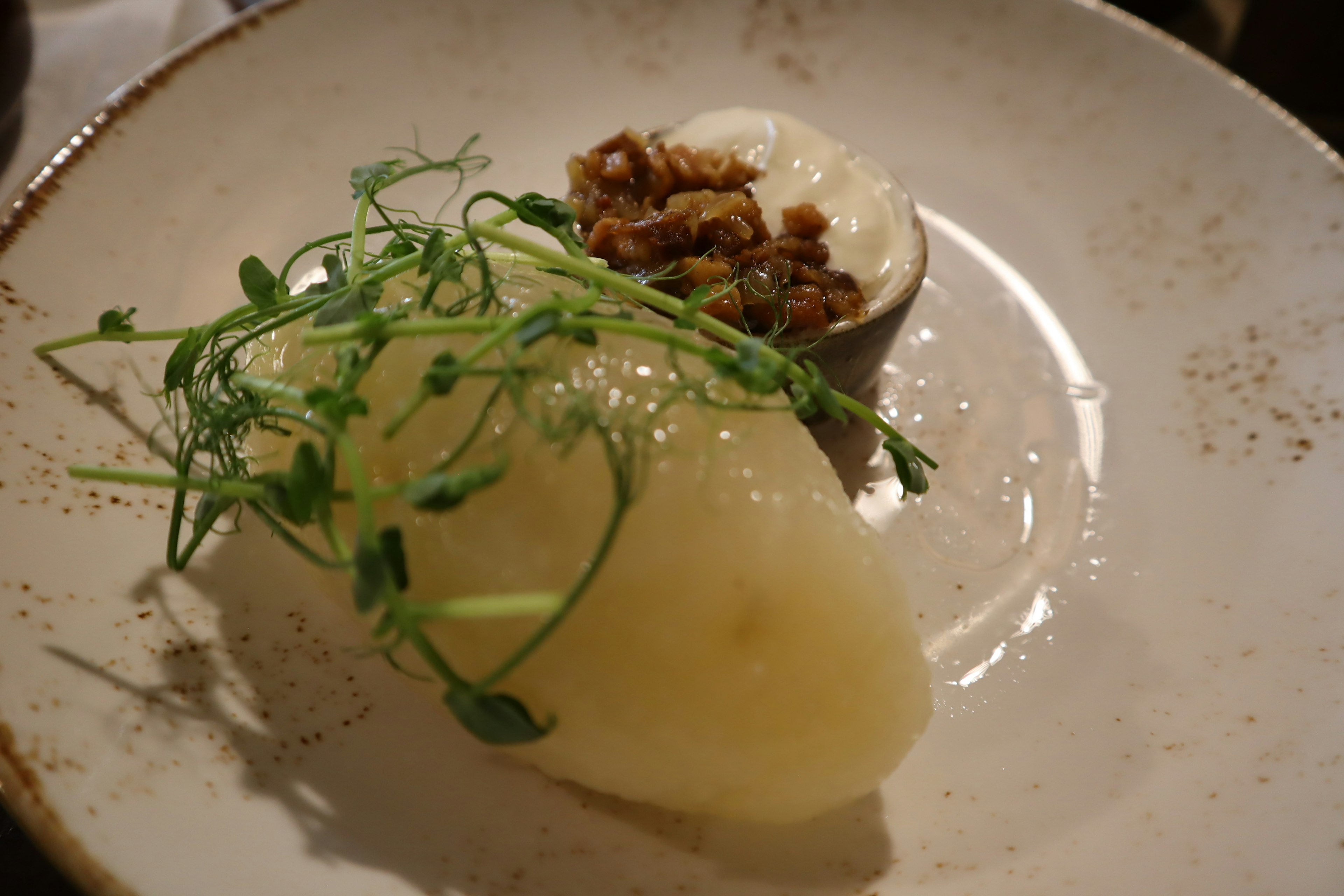 Creamy potato puree garnished with crispy toppings on a plate