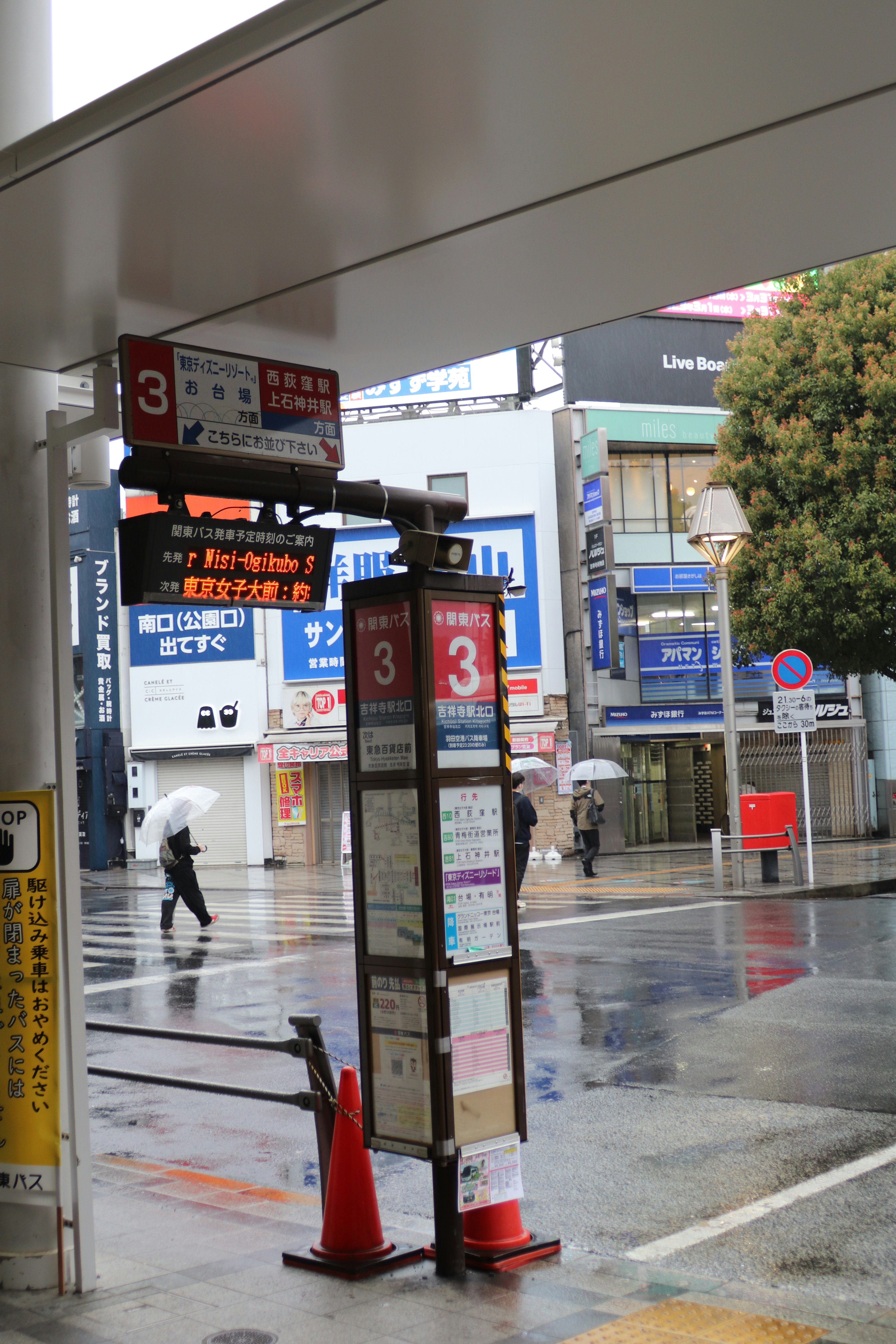 雨中公交站标志与周围建筑