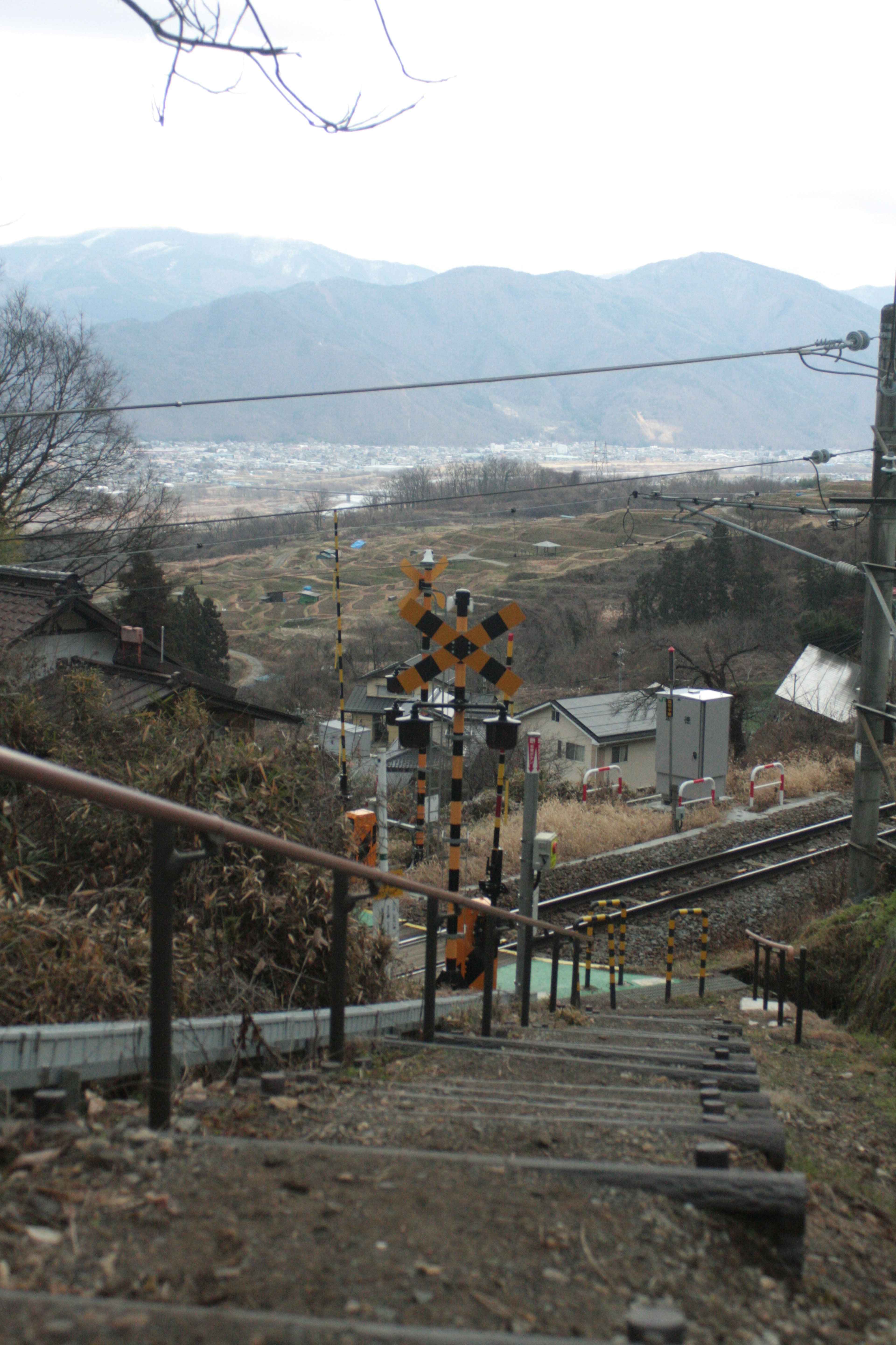 Vue d'un signal ferroviaire et d'un paysage rural depuis des escaliers