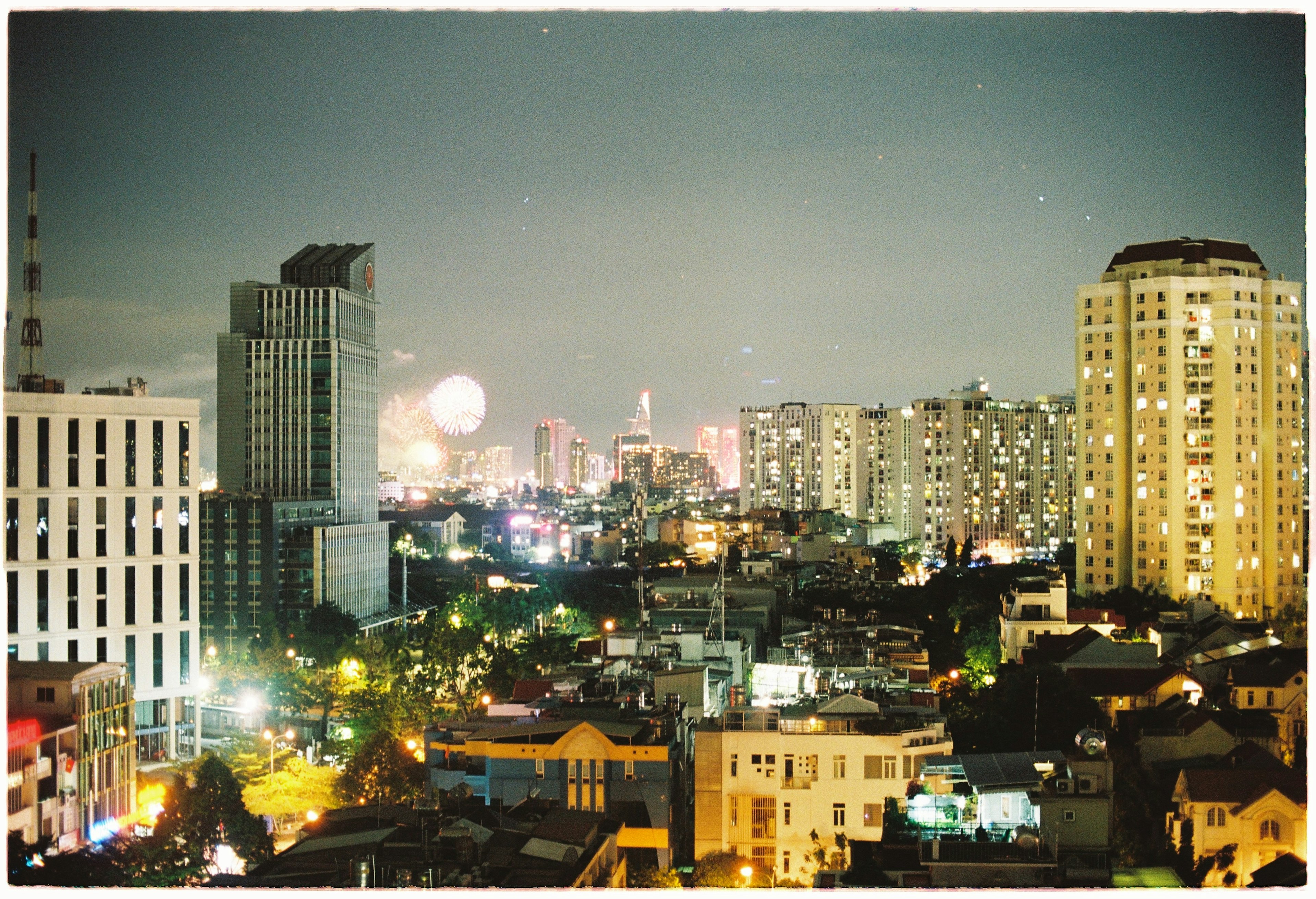 Night cityscape featuring high-rise buildings and residential areas Bright streetlights and colorful lights