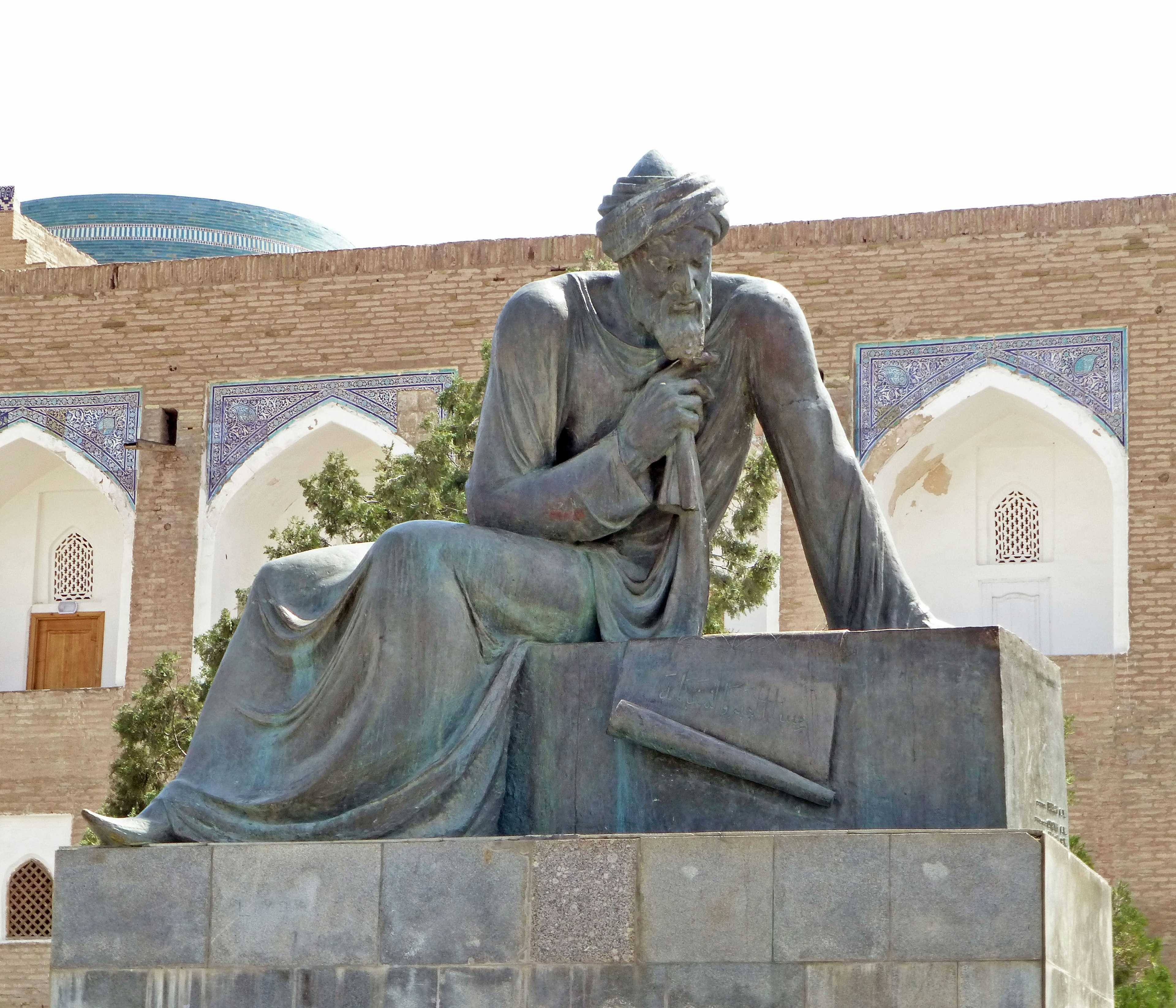 Bronze statue of a seated figure holding a document in a thoughtful pose