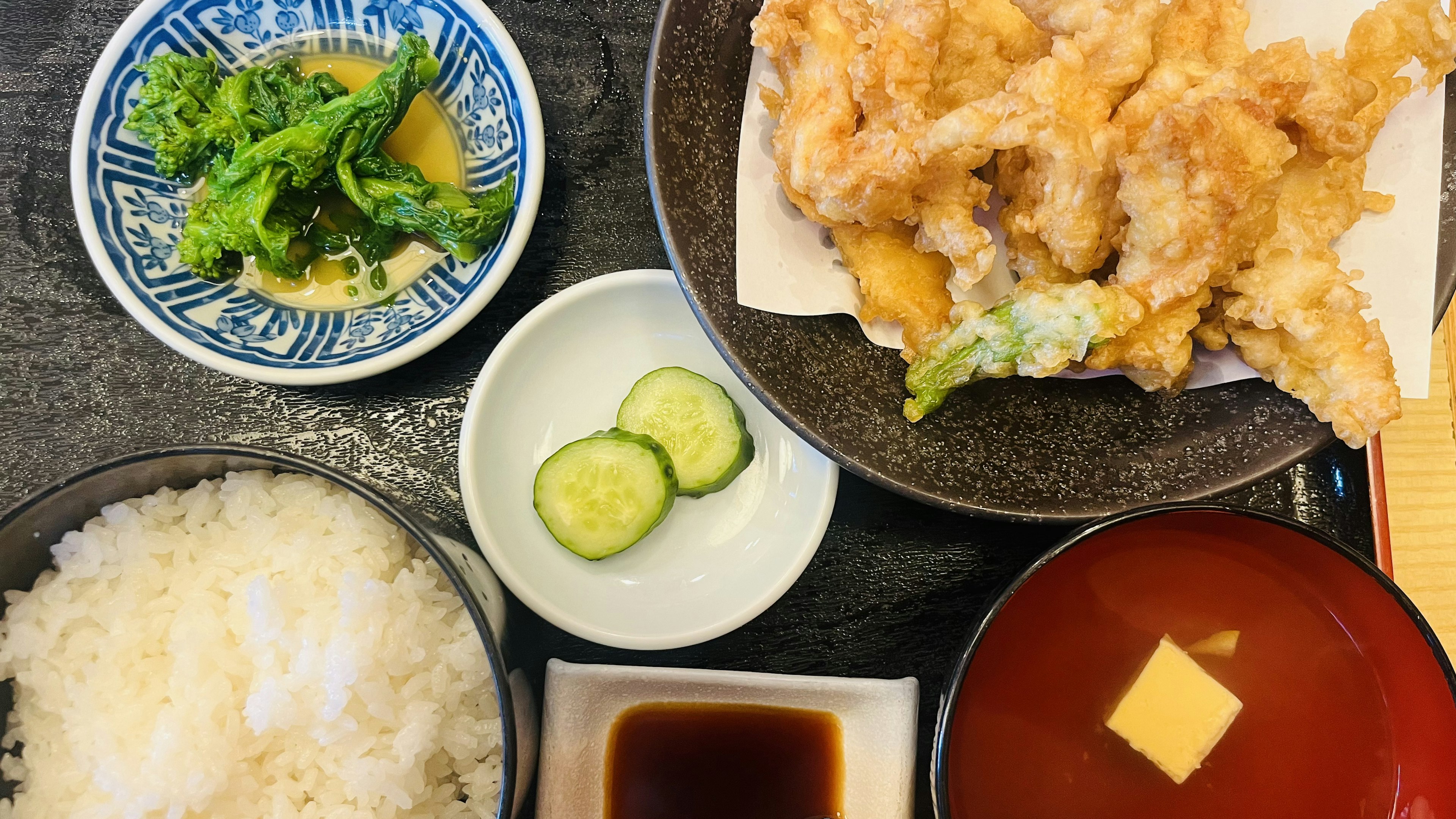 An assortment of tempura with rice, miso soup, pickles, and a small dish of vegetables