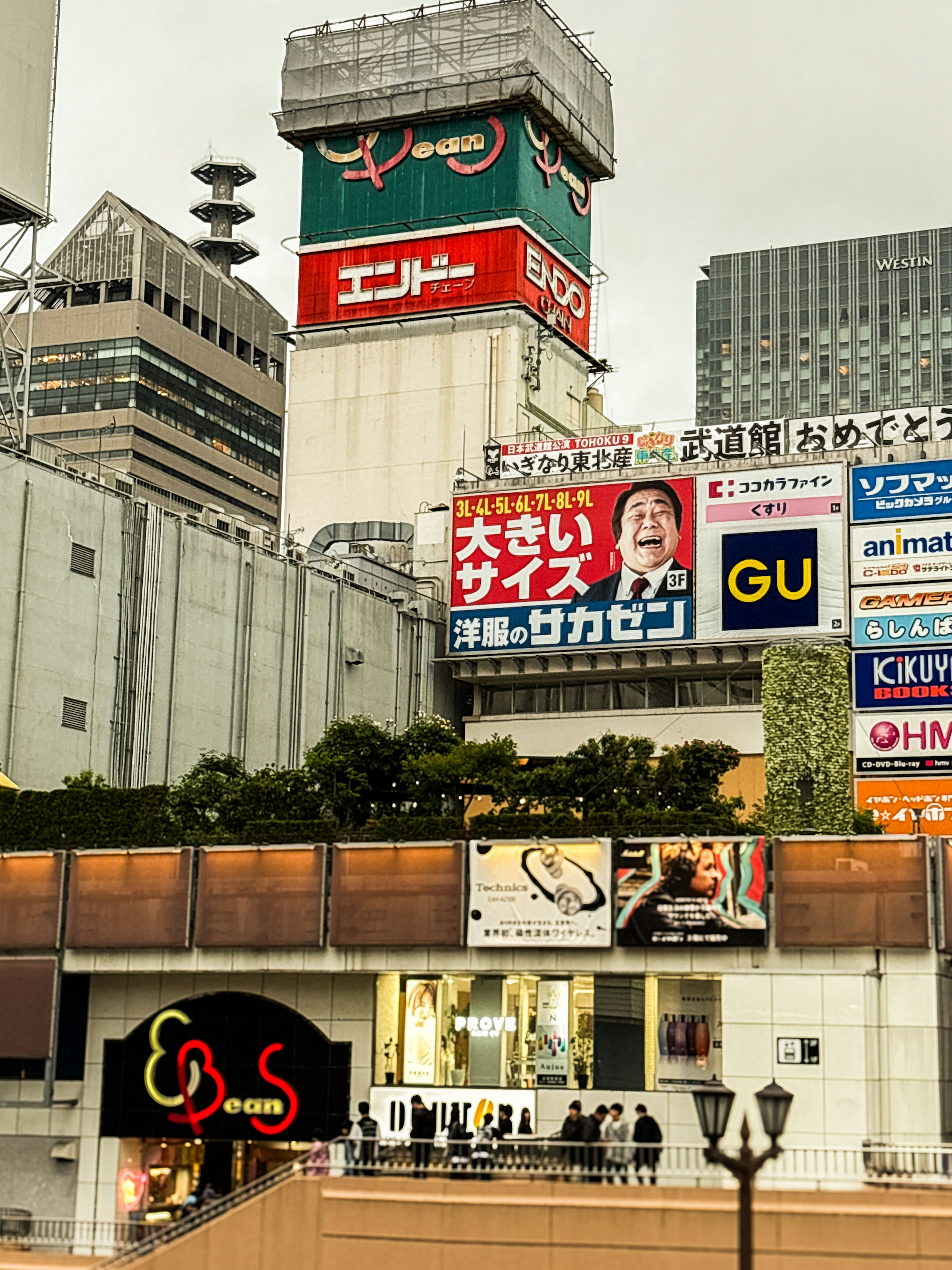 Eksterior gedung komersial di Shibuya dengan iklan dan papan nama besar