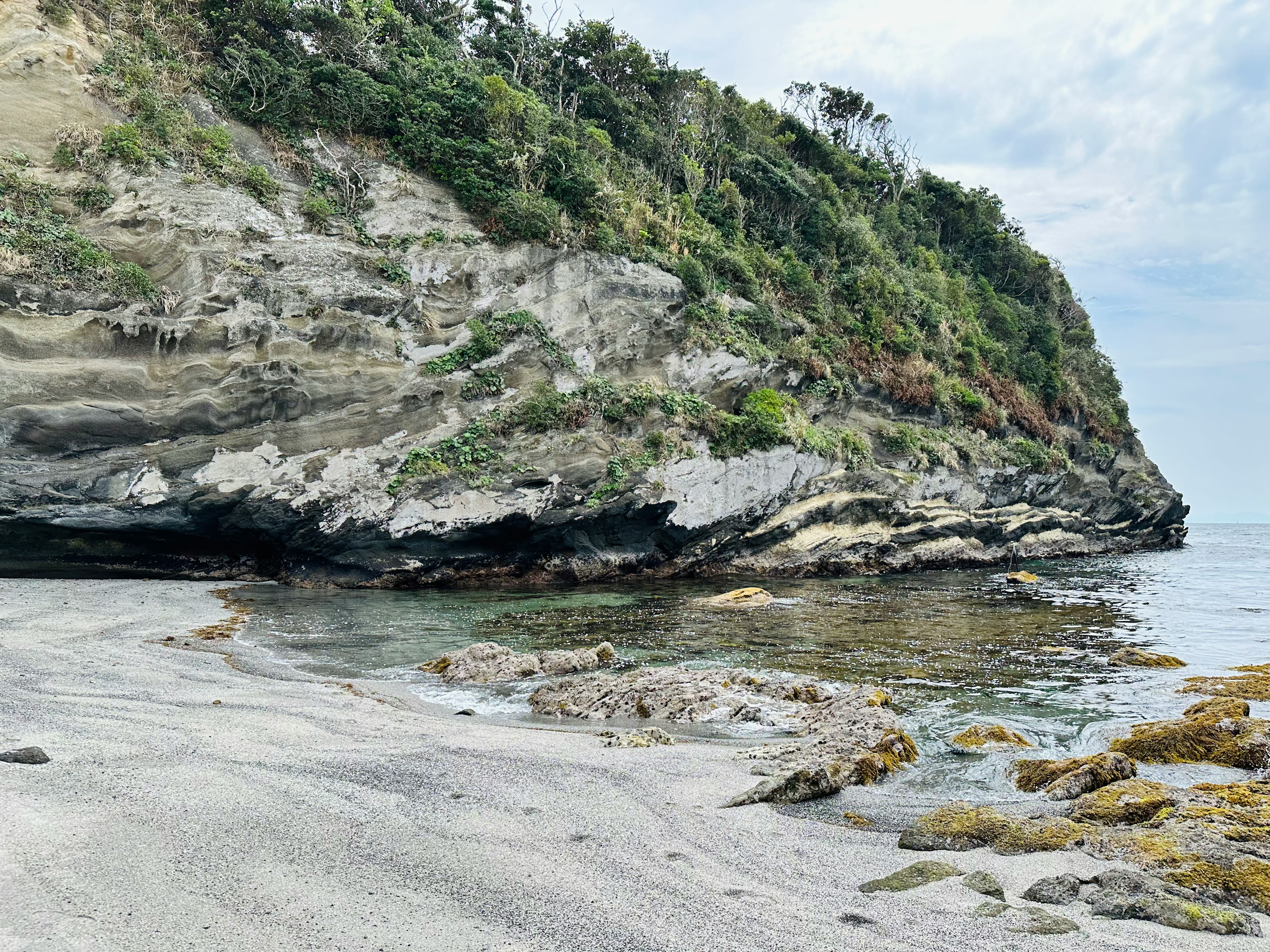 静かな海岸線と岩の崖が特徴の風景