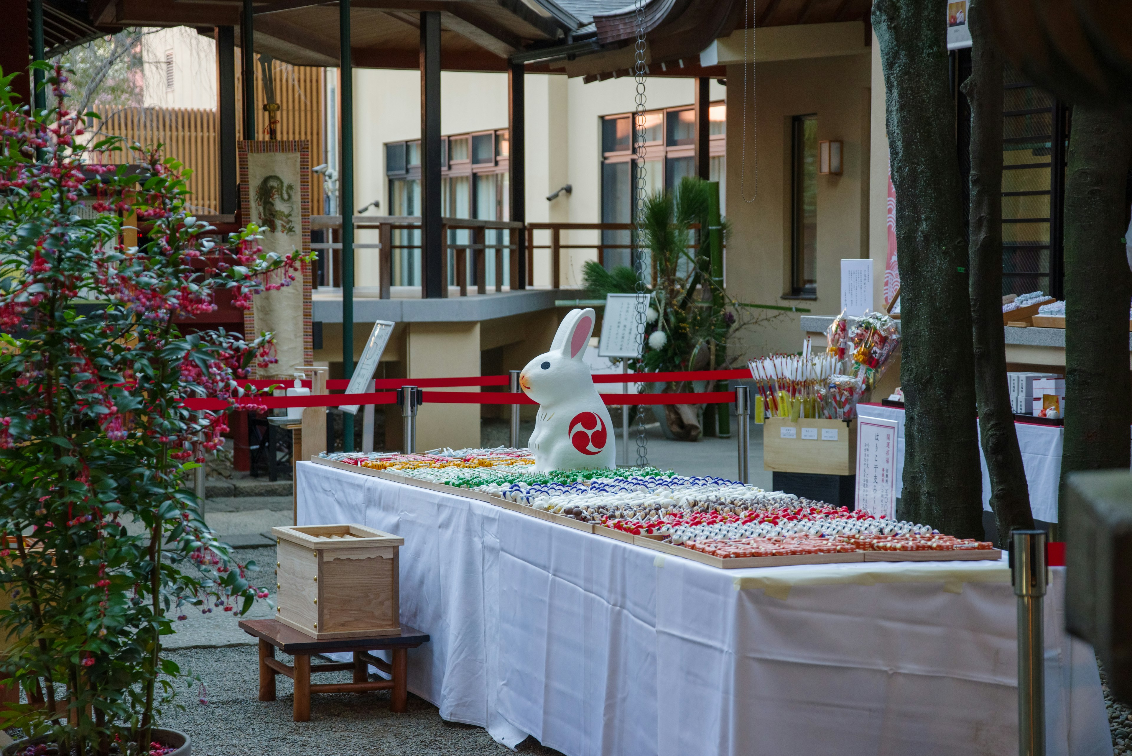 Outdoor table displaying colorful sweets and a white rabbit statue