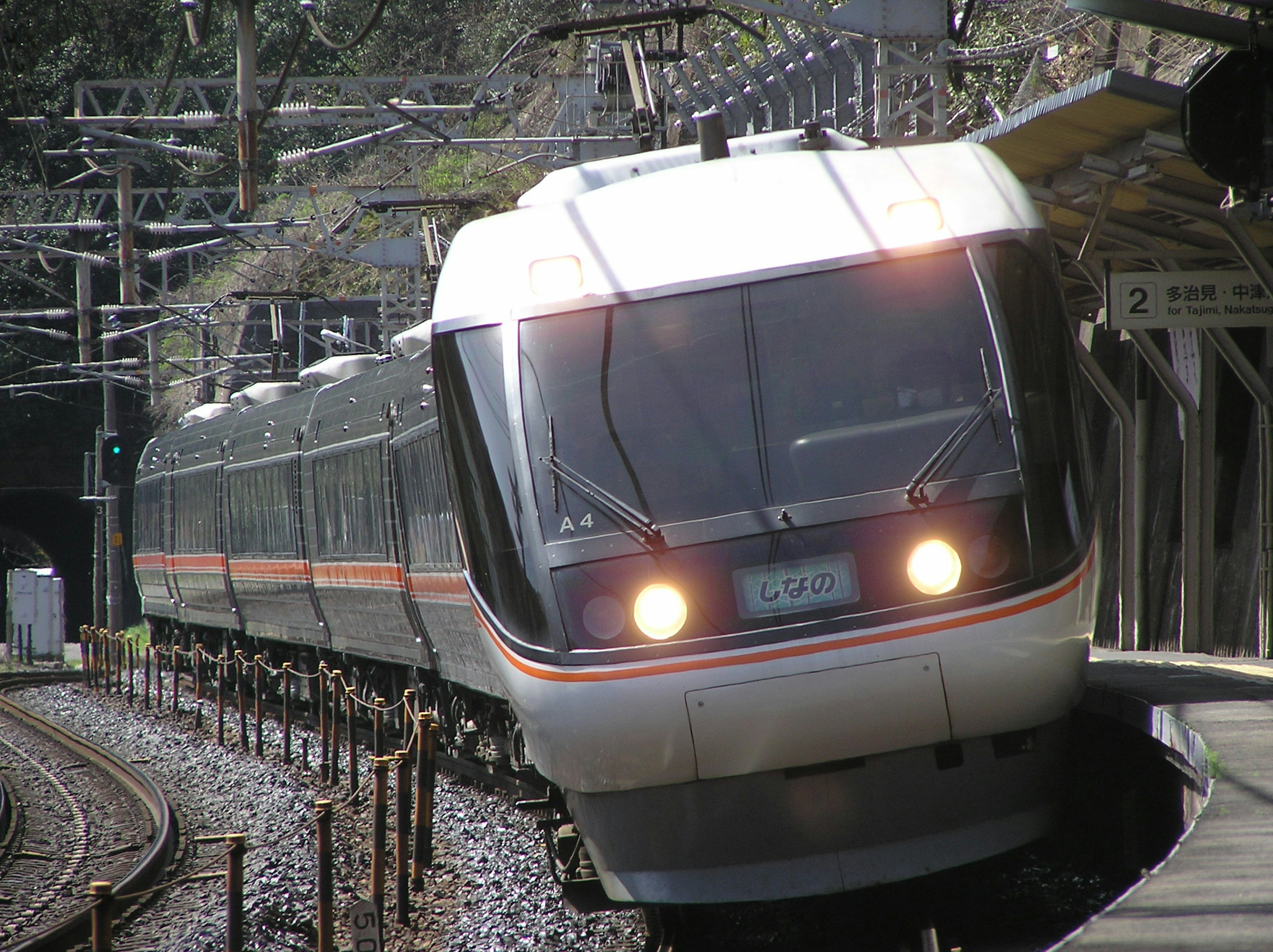 Image of a train exiting a tunnel and turning Bright headlights and streamlined design are prominent