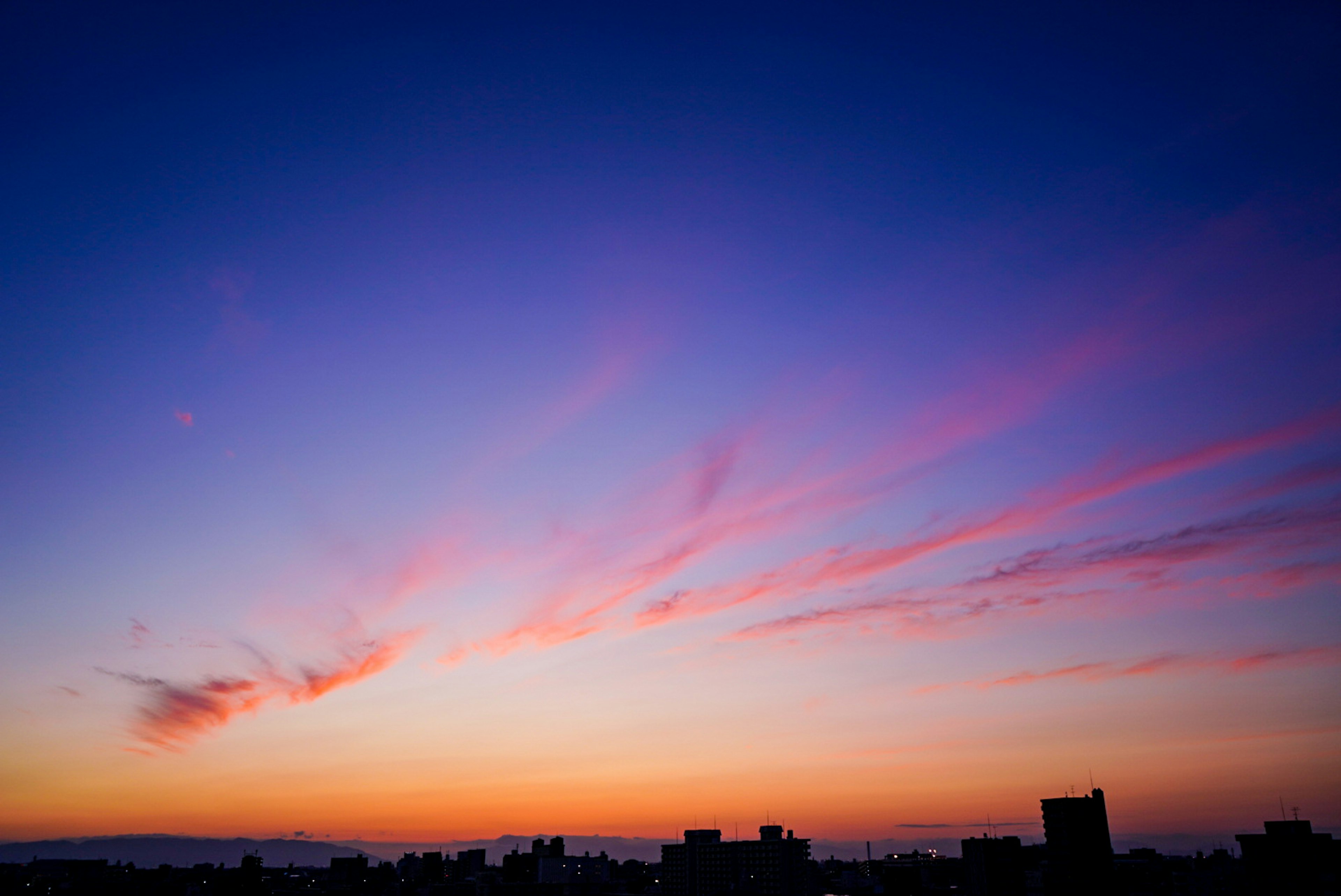 夕焼けの空にピンクとオレンジのグラデーションが広がる