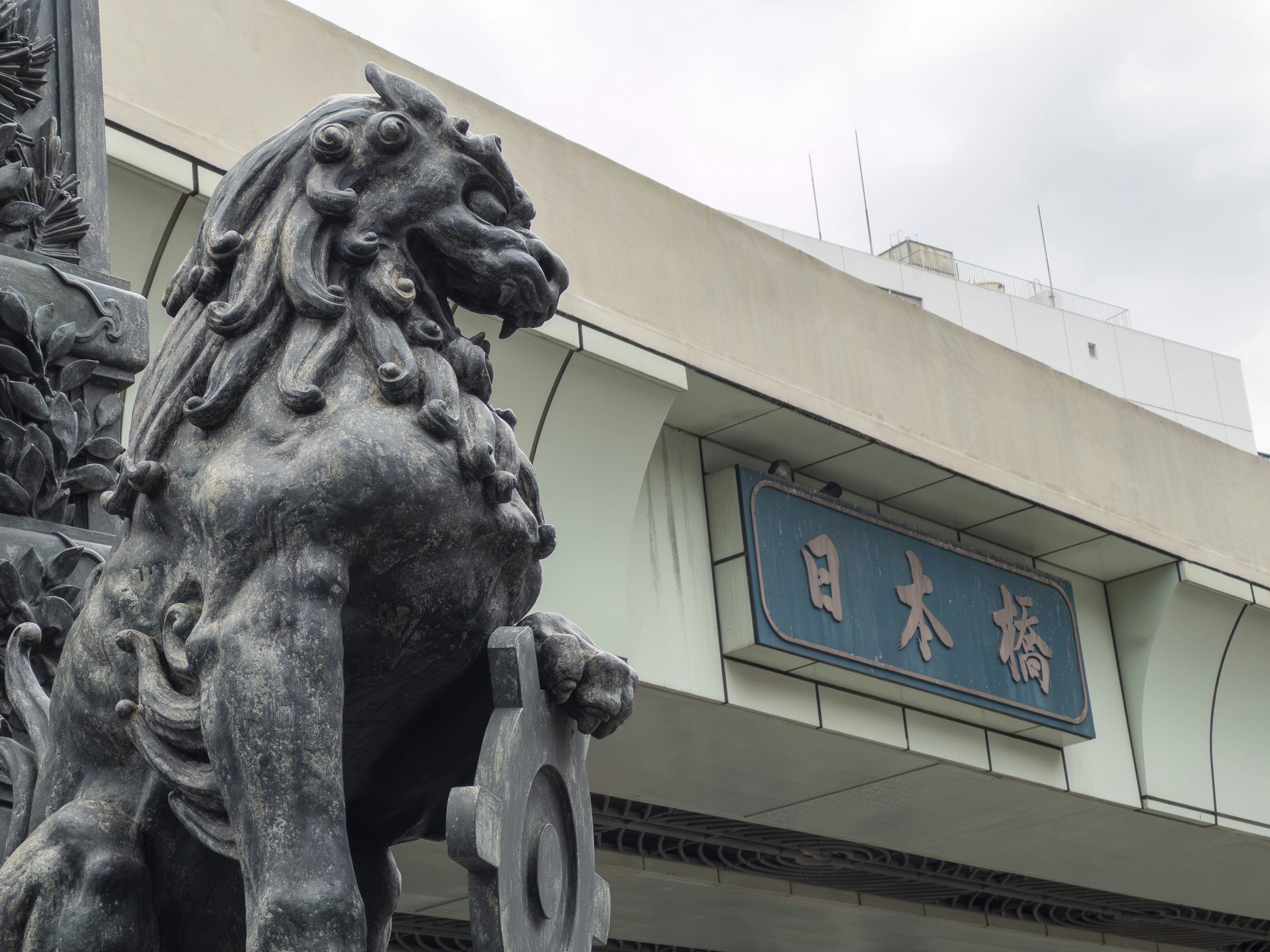 Foto von einer Löwenstatue in Nihonbashi mit einem Schild auf Japanisch