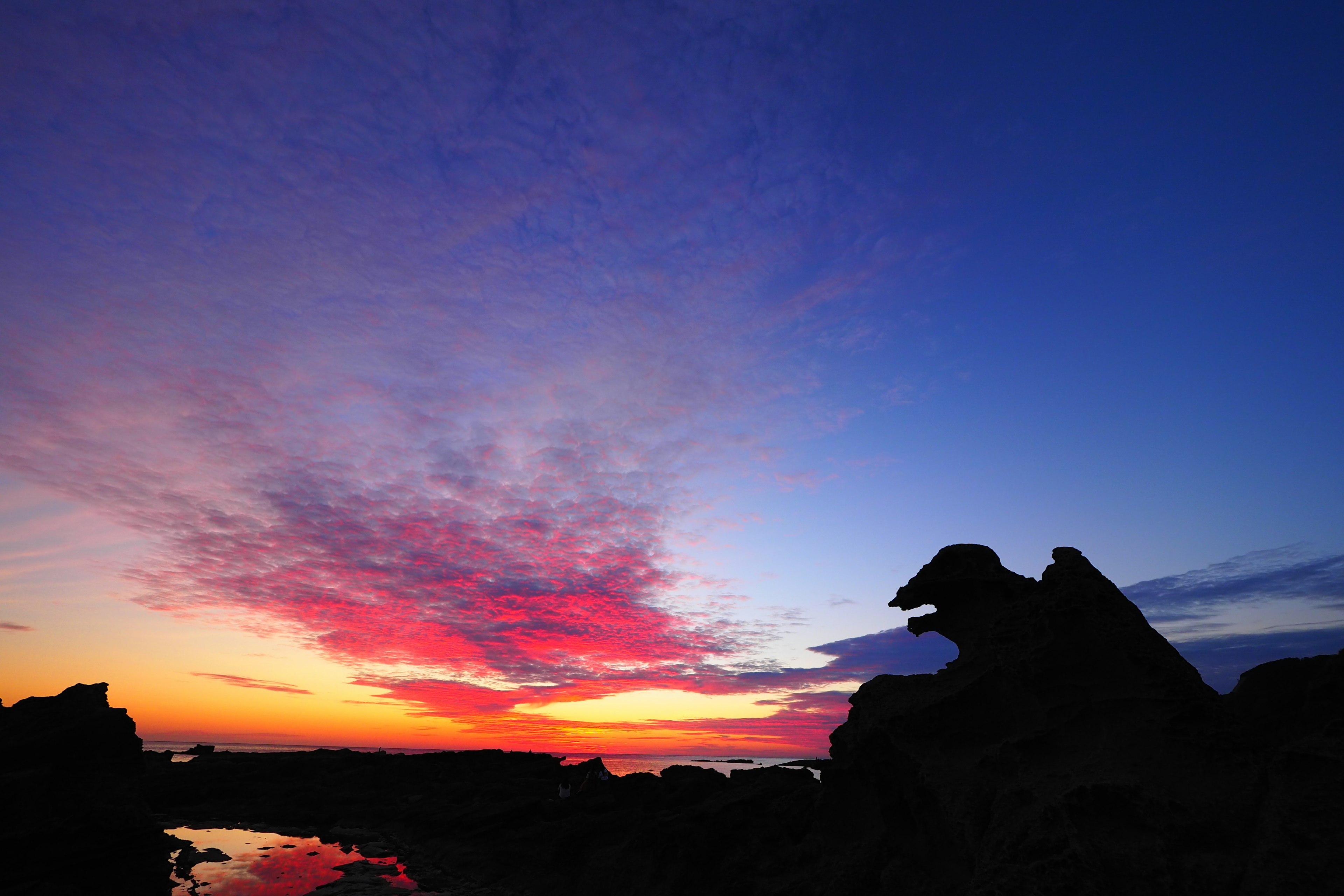 Stunning sunset sky with silhouette of rocks