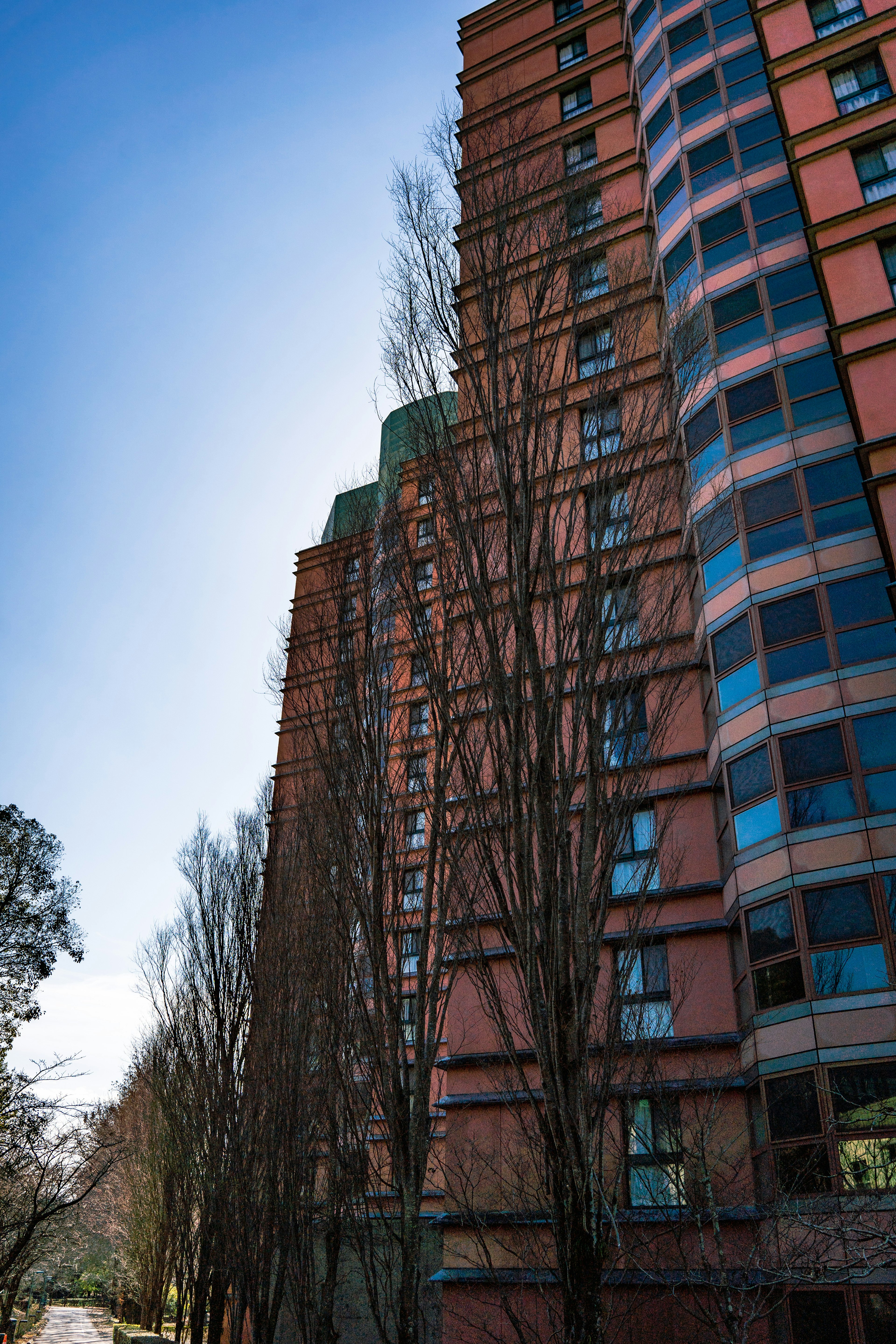 Bâtiment haut en briques rouges avec des arbres environnants