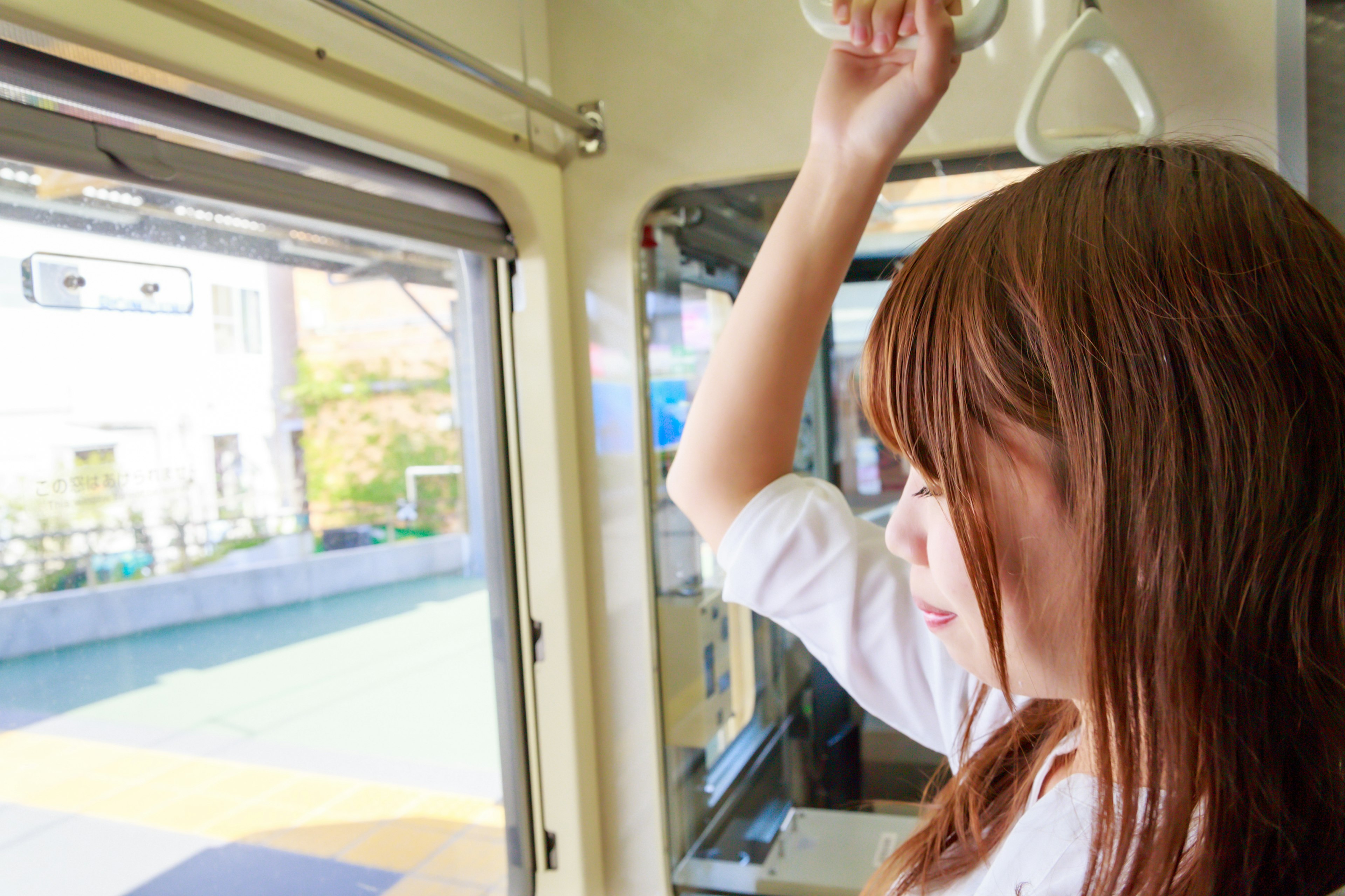 電車の中で窓の外を見つめる女性の横顔