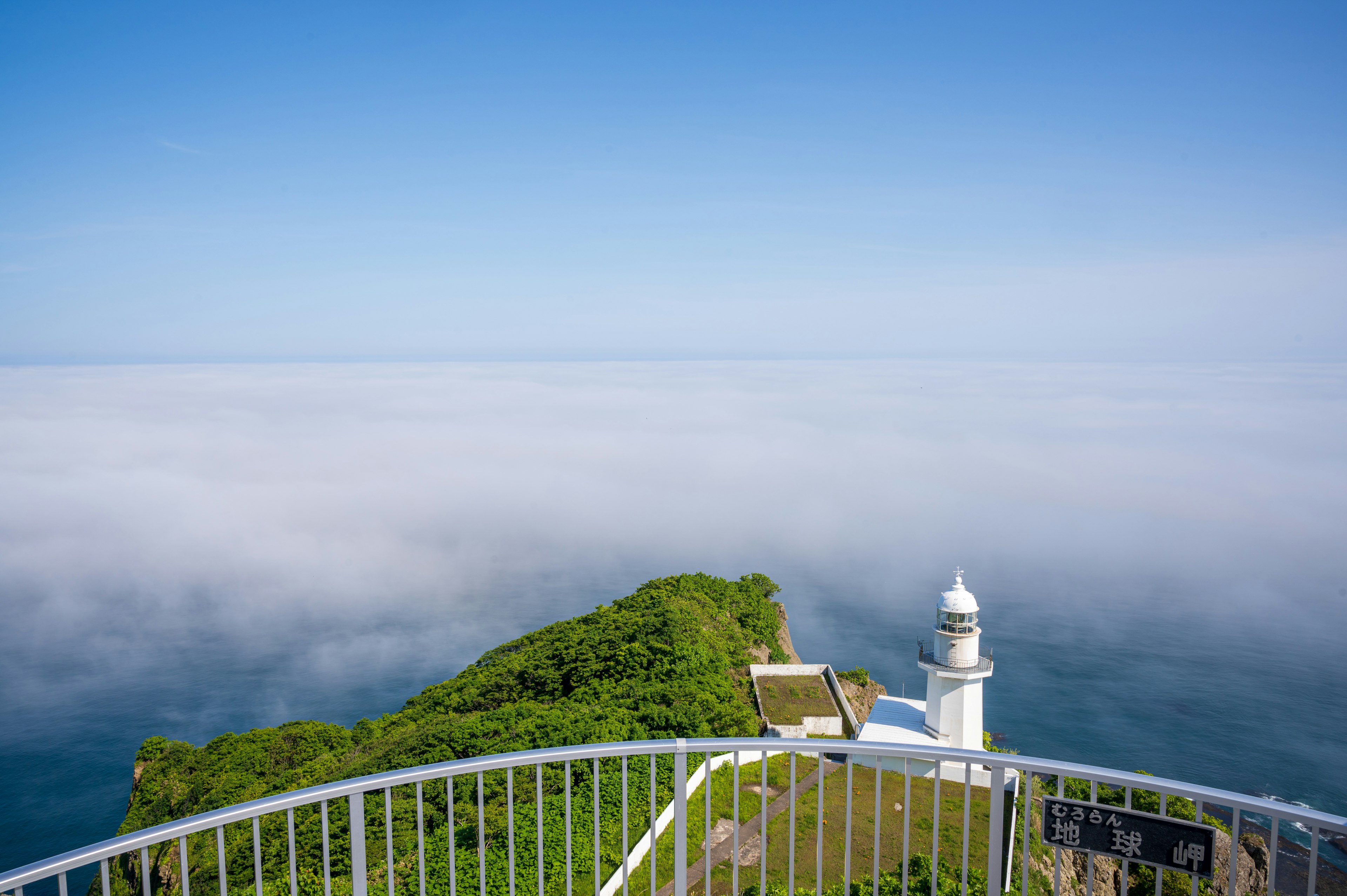 青空と雲海を背景にした灯台の風景