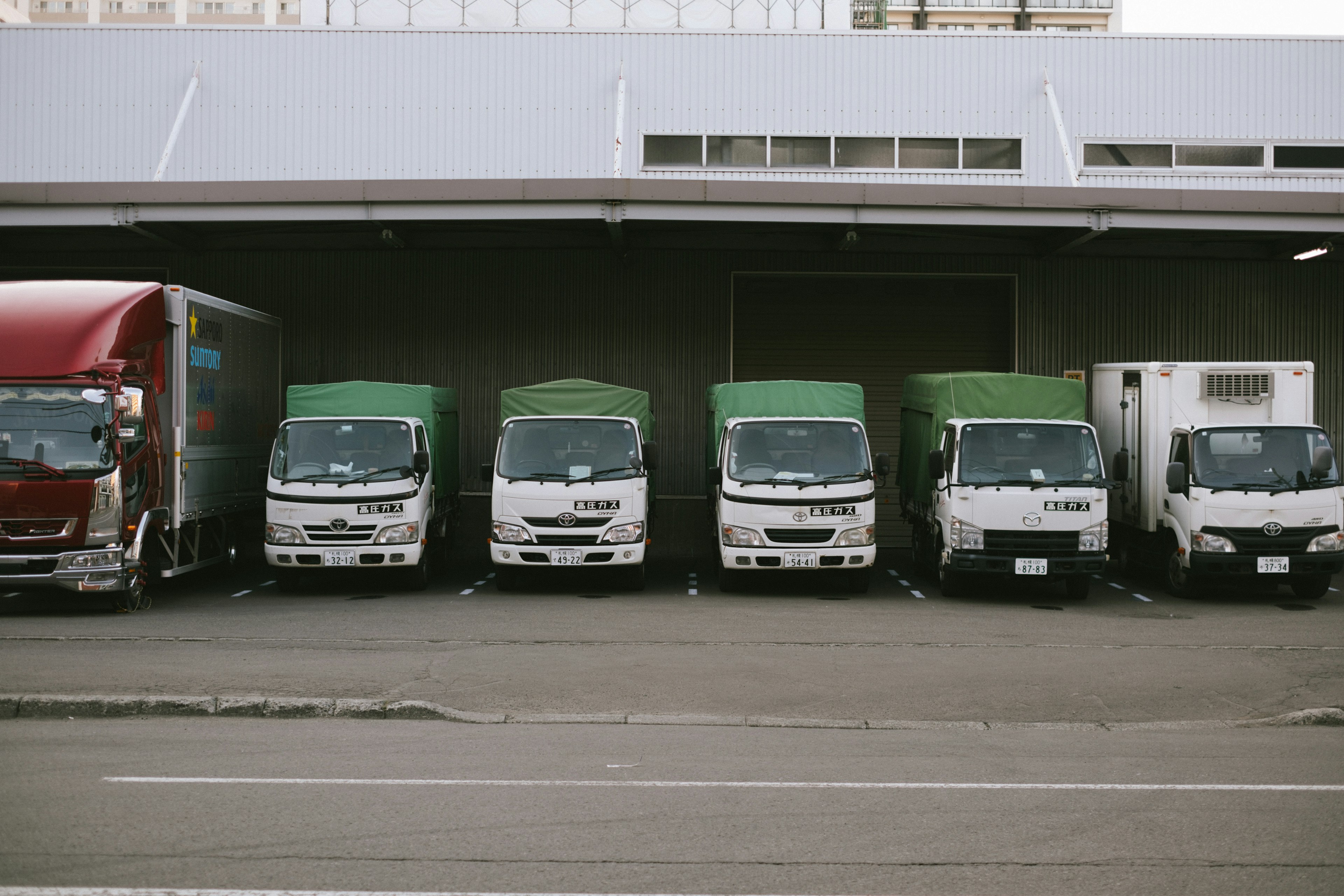 Una fila di vari camion per consegne parcheggiati in un'area