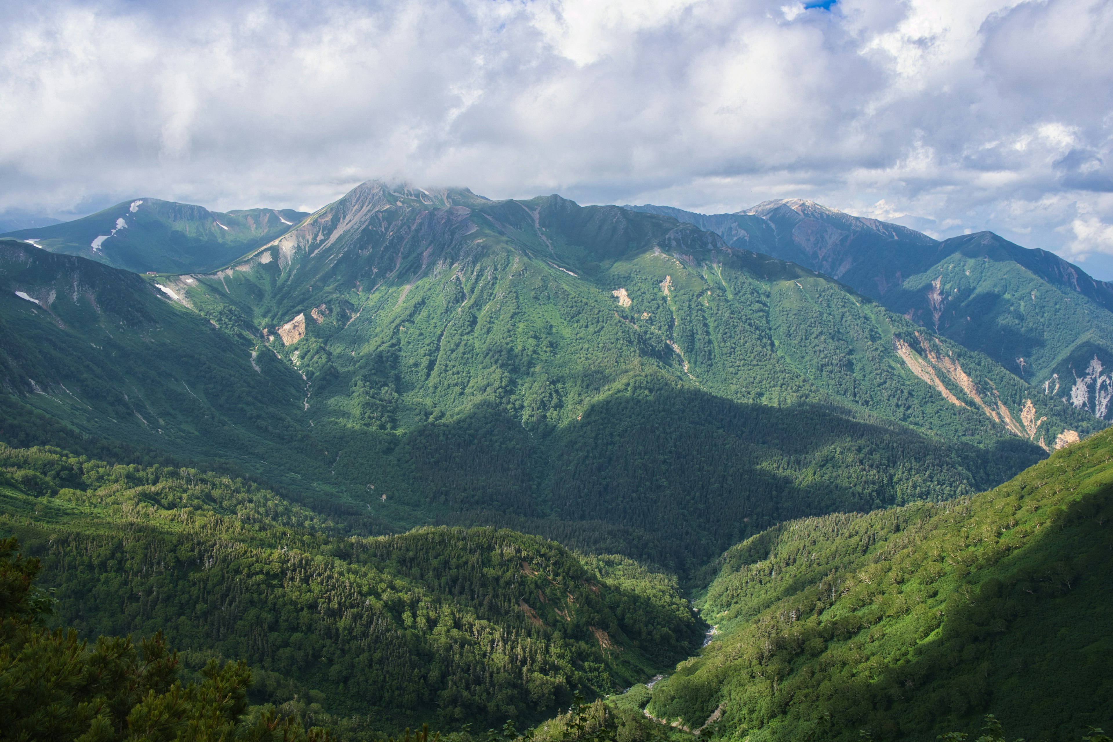 Scenic view of green mountains under a blue sky