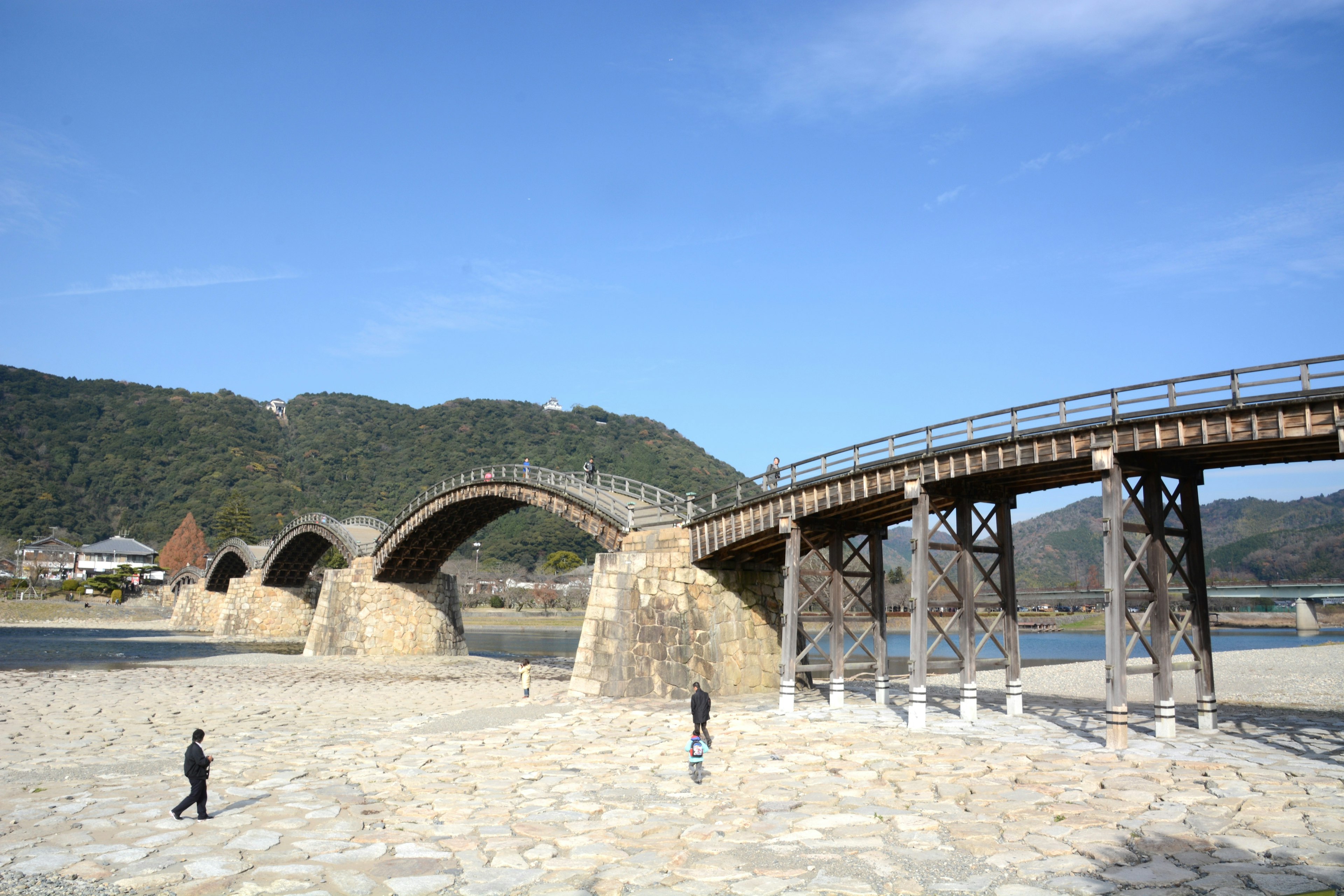 Hermoso puente de madera en arco con cielo azul claro