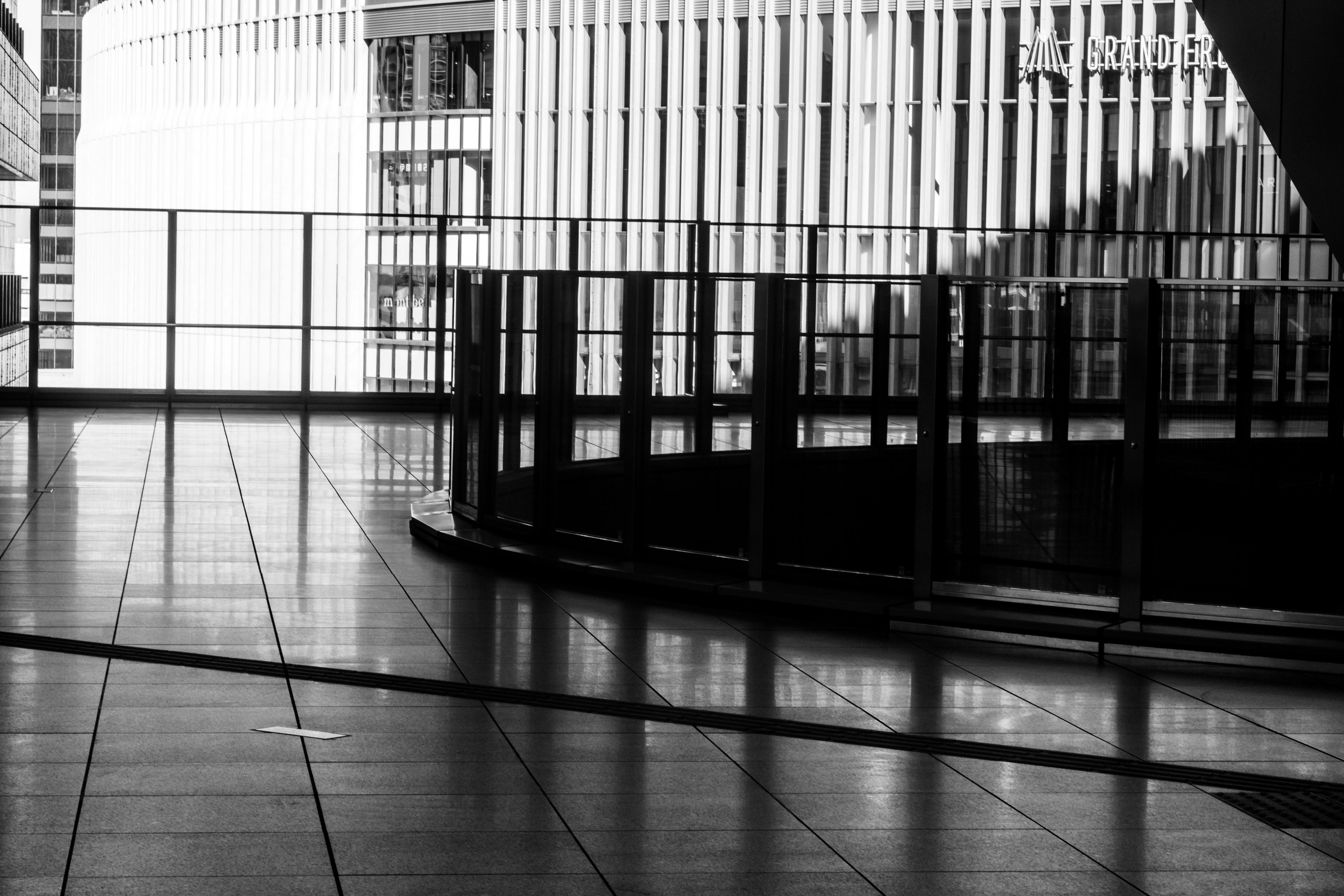 Espace intérieur moderne en noir et blanc avec un sol réfléchissant et une rampe en verre